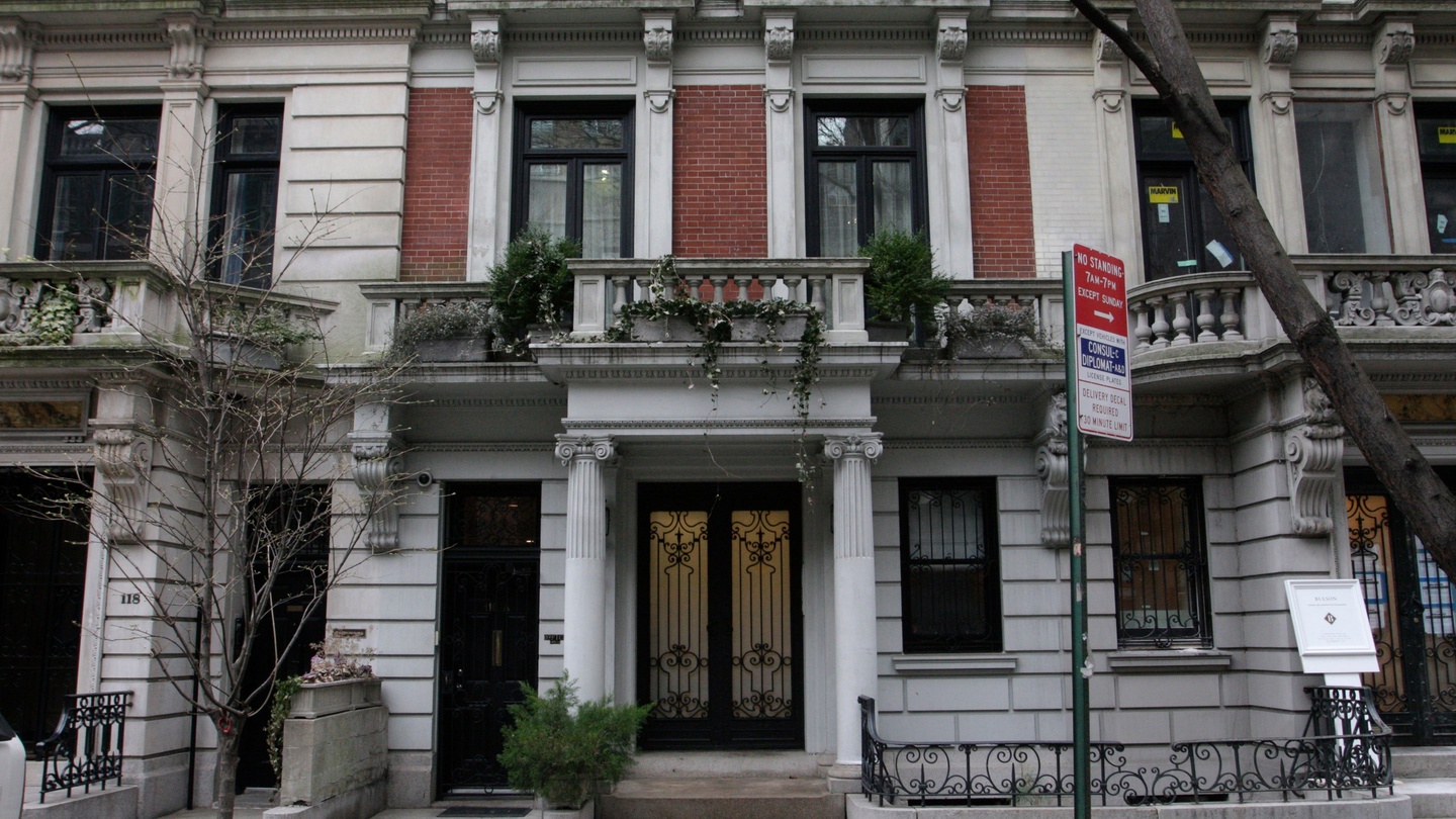 Exterior view of Ghislaine Maxwell’s former New York City townhouse on East 65th Street, featuring classic architectural details and iron gates.