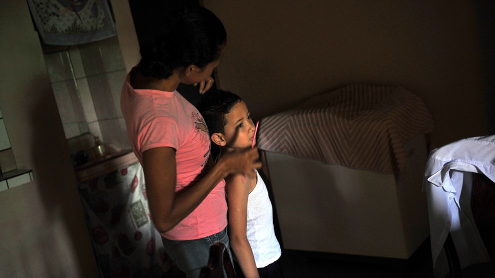 Kenier Alvarado coiffe son petit Geral Sequeira avant de l'emmener à l'école. San Jose, Costa Rica
