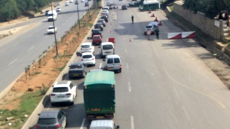Photo prise le 20 septembre 2019 montrant des véhicules de la police bloquant un axe menant à Alger, près de la capitale algérienne.
