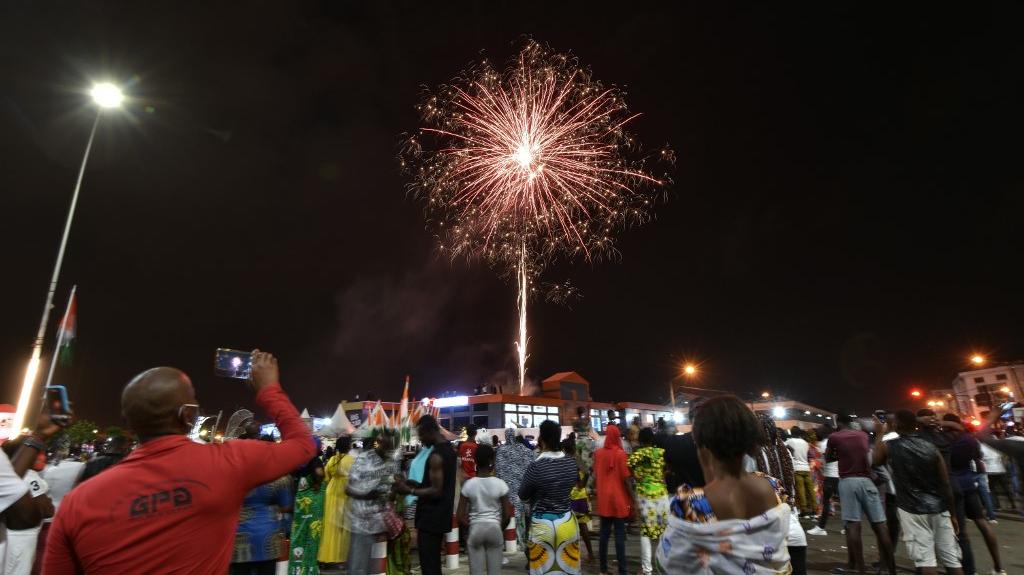 Les Ivoiriens regardent un feu d'artifice pour sonner le Nouvel An, à Koumassi, un quartier d'Abidjan, le 1er janvier 2021, alors que les nations du monde entier organisent des célébrations discrètes pour aider à freiner la propagation du nouveau coronavirus, Covid-19.

