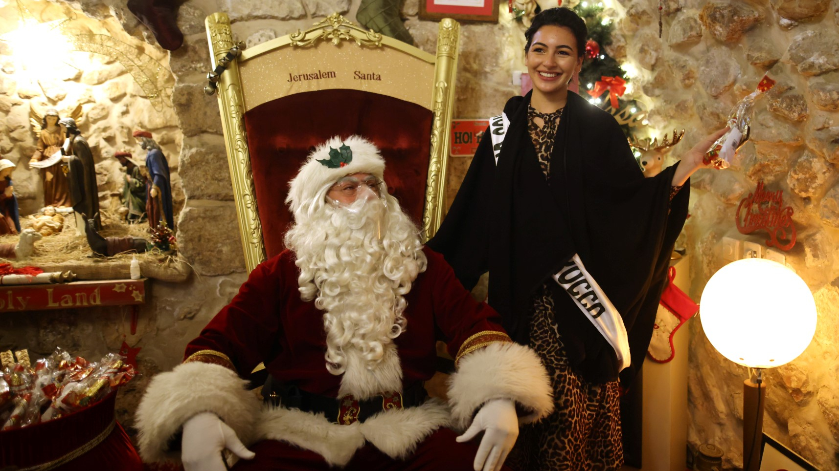 Miss Maroc pose avec un Père Noël lors d'une visite des candidates du concours Miss Univers dans la vieille ville de Jérusalem, en Israël, le 1er décembre 2021, dans le cadre de leur visite de la ville sainte. La 70e édition de Miss Univers se tiendra à Eilat, le 12 décembre.
