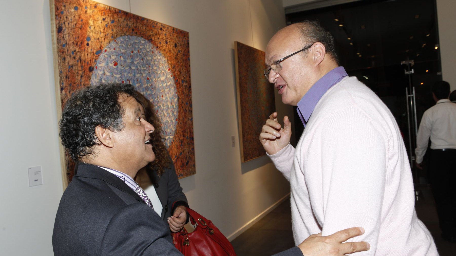 Moulay Ahmed Belghiti et Mehdi Qotbi échangent tout en déambulant parmi les oeuvres d'art. 
