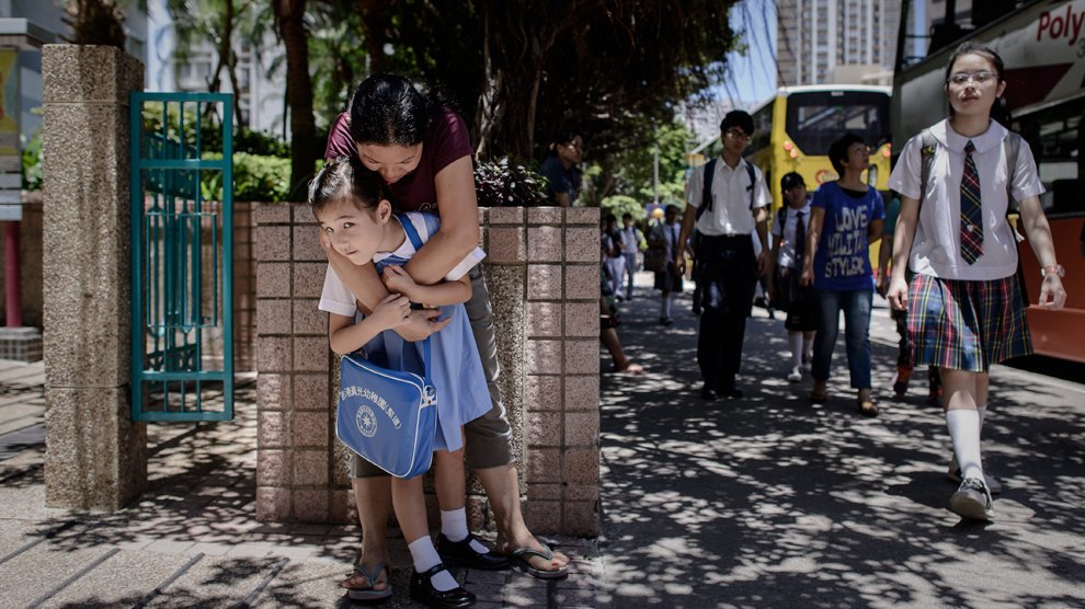 Maya, 5 ans, dans les bras de sa grand-maman avant de faire son entrée à l'école, Hong Kong
