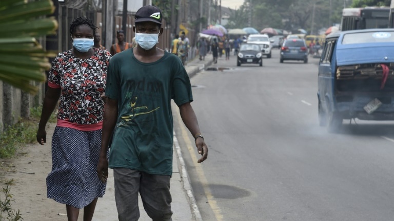 Des passants protégés par des masques dans un quartier de Lagos, le 28 février 2020.
