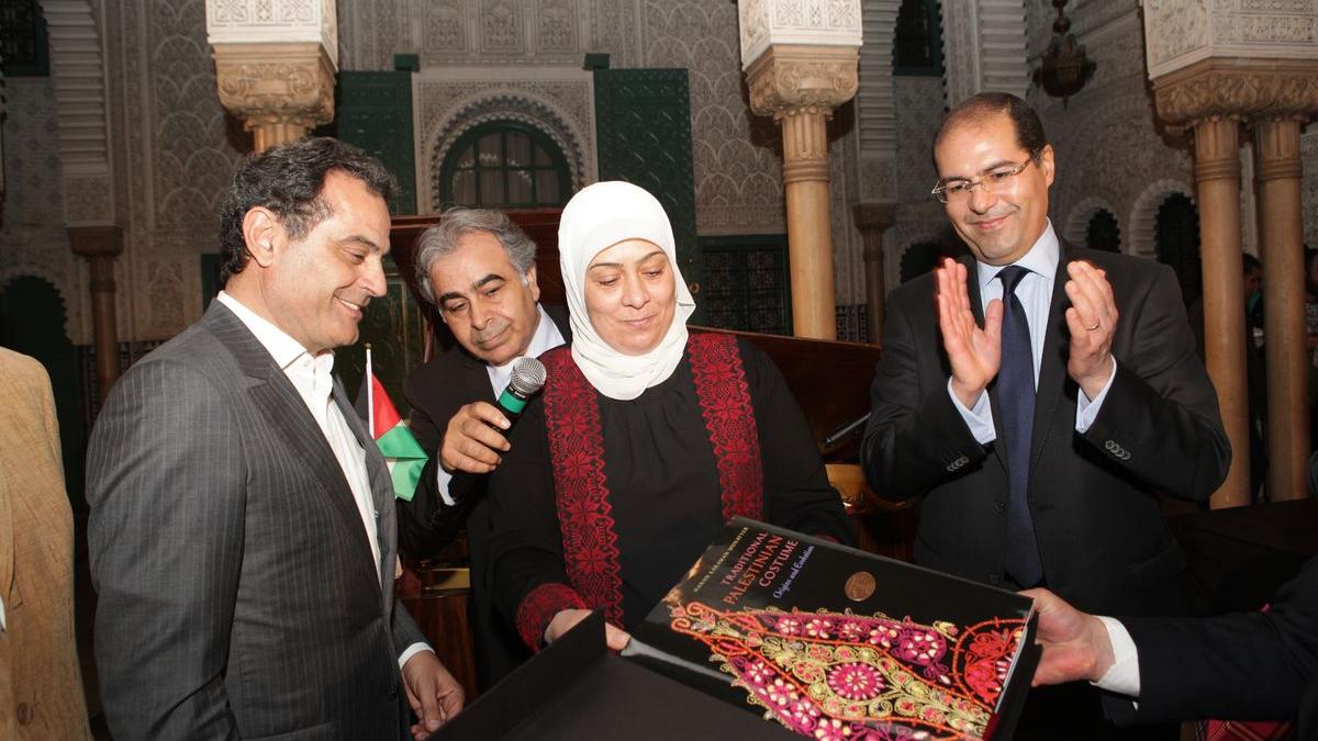 Rachid Andaloussi, président de l'Association Casamémoire reçoit un beau livre sur les costumes traditionnels palestiniens de Mme Laila Ghanem, mairesse de Ramallah, et le Wali du grand Casablanca Khalid Safir.
