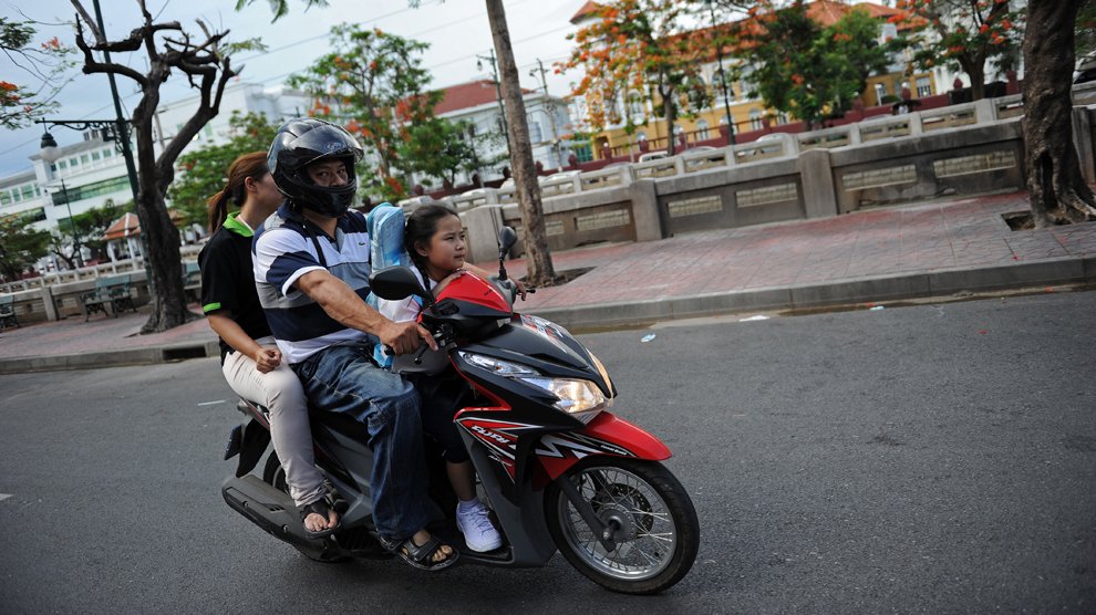 C'est la petite Chamaya Pamutito qui conduit la moto pour aller à l'école avec ses parents! Bangkok, Thaïlande 
