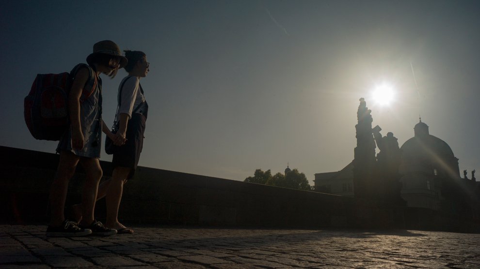 Ema Lanska, 7 ans, traverse avec sa maman le pont Charles, à Pragues, pour commencer sa journée d'école sous les moires d'un magnifique soleil levant.
