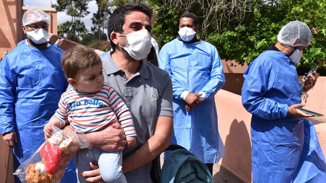 Lino dans les bras de son père sortant de l'hôpital Arrazi de Marrakech après avoir vaincu le Coronavirus.
