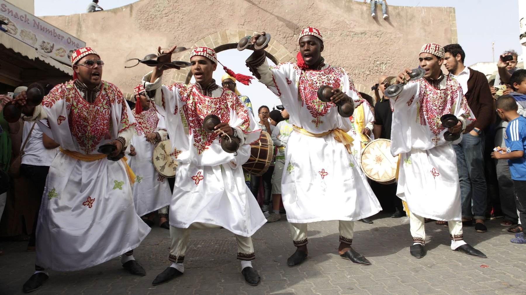 Gnaouas défilent entre les murailles or qui veillent sur leurs ancestrales traditions.  
