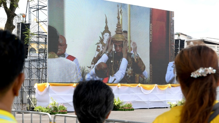 Des Thaïlandais suivent sur un écran géant la cérémonie de couronnement du roi Maja Vajiralongkorn, le 4 mai 2019 à Bangkok.
