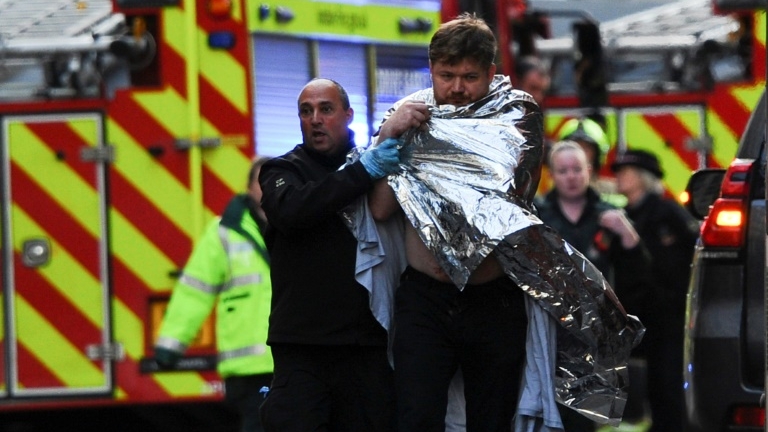 Un policier aide un homme blessé près du London Bridge, le 29 novembre 2019 à Londres.
