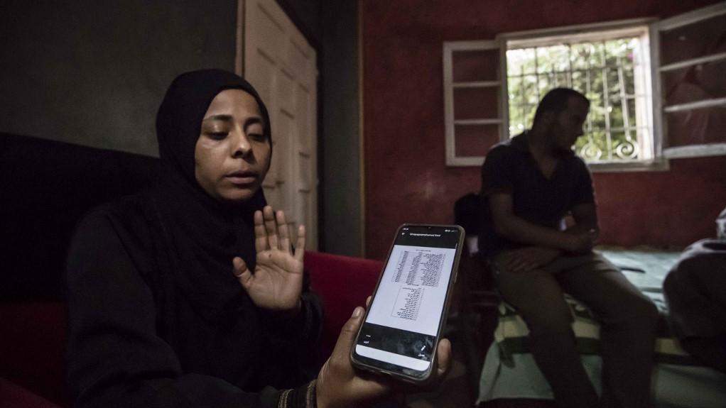 Walaa Fathi, vétérinaire égyptienne, montre sur son smartphone la liste des 17 jeunes candidats à l'émigration diparus en Libye. 
