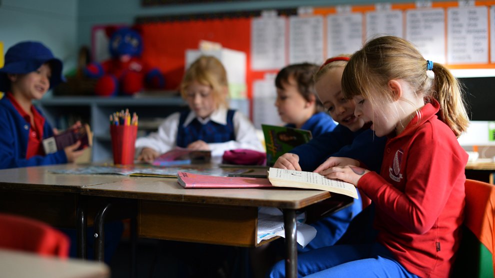 Petites écolières de 6 ans manifestement heureuses de retrouver l'école et les livres, Sydney, Australie.  
