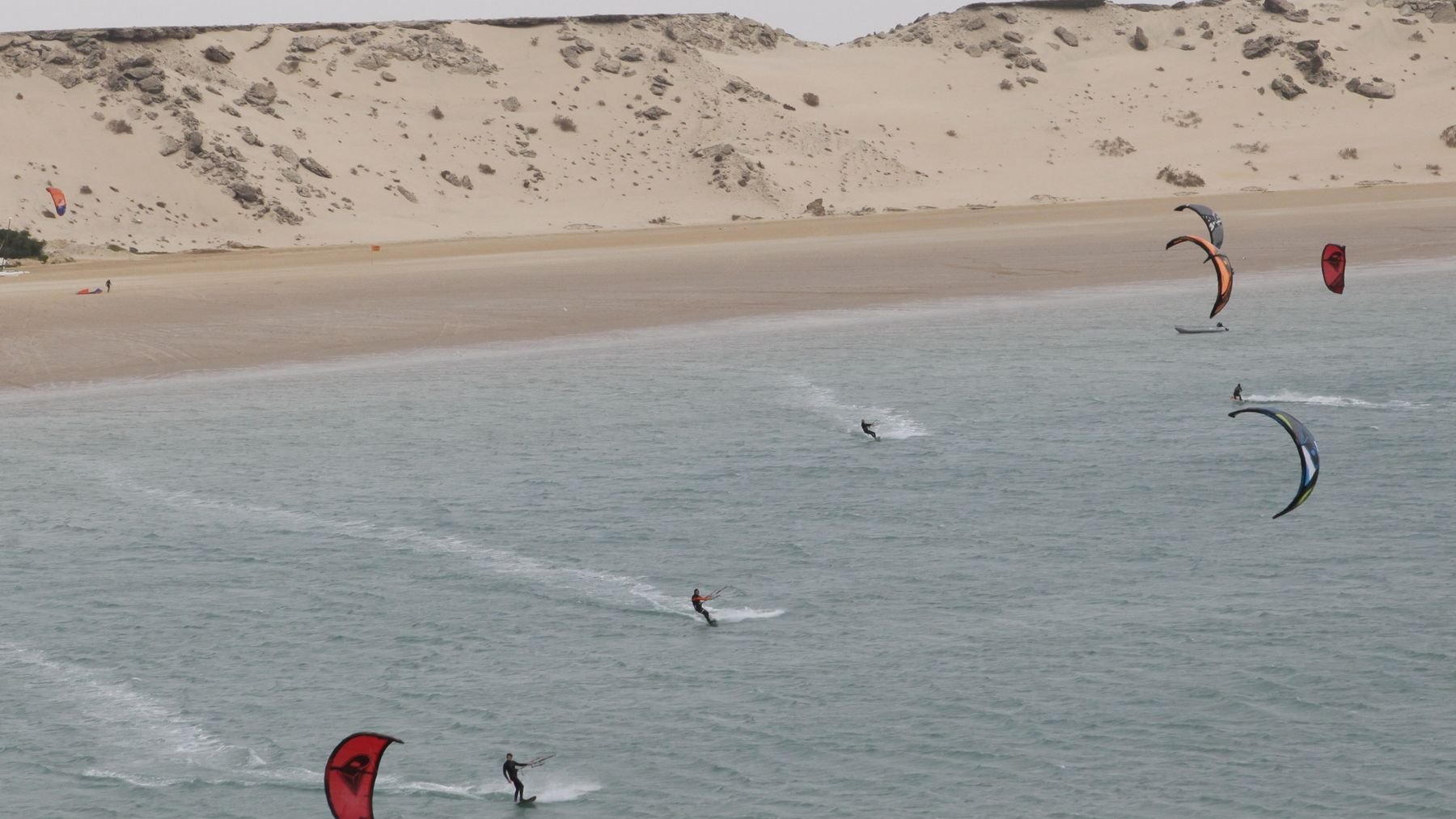 Les kitesurfeurs se sont élancés, fendant les eaux de traînées blanches écumantes. 
