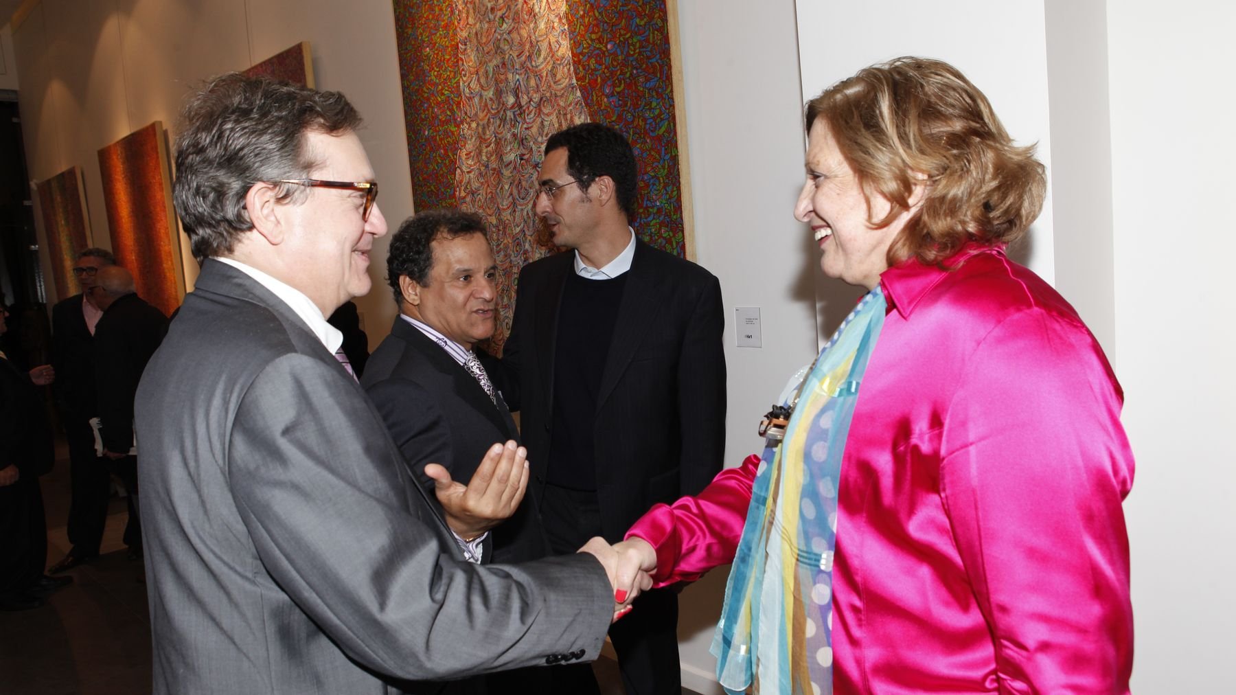 Le consul général de France et Nadia Salah, présents pour le vernissage, se saluent sous le regard heureux de l'artiste. 
