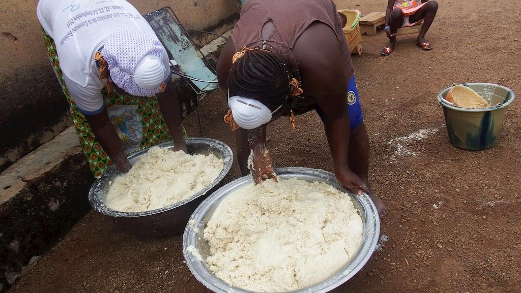Après l'étape du moulin, les femmes malaxes la pâtes de manioc. Il reste encore quelques étapes avant d'obtenir de l'attiéké.
