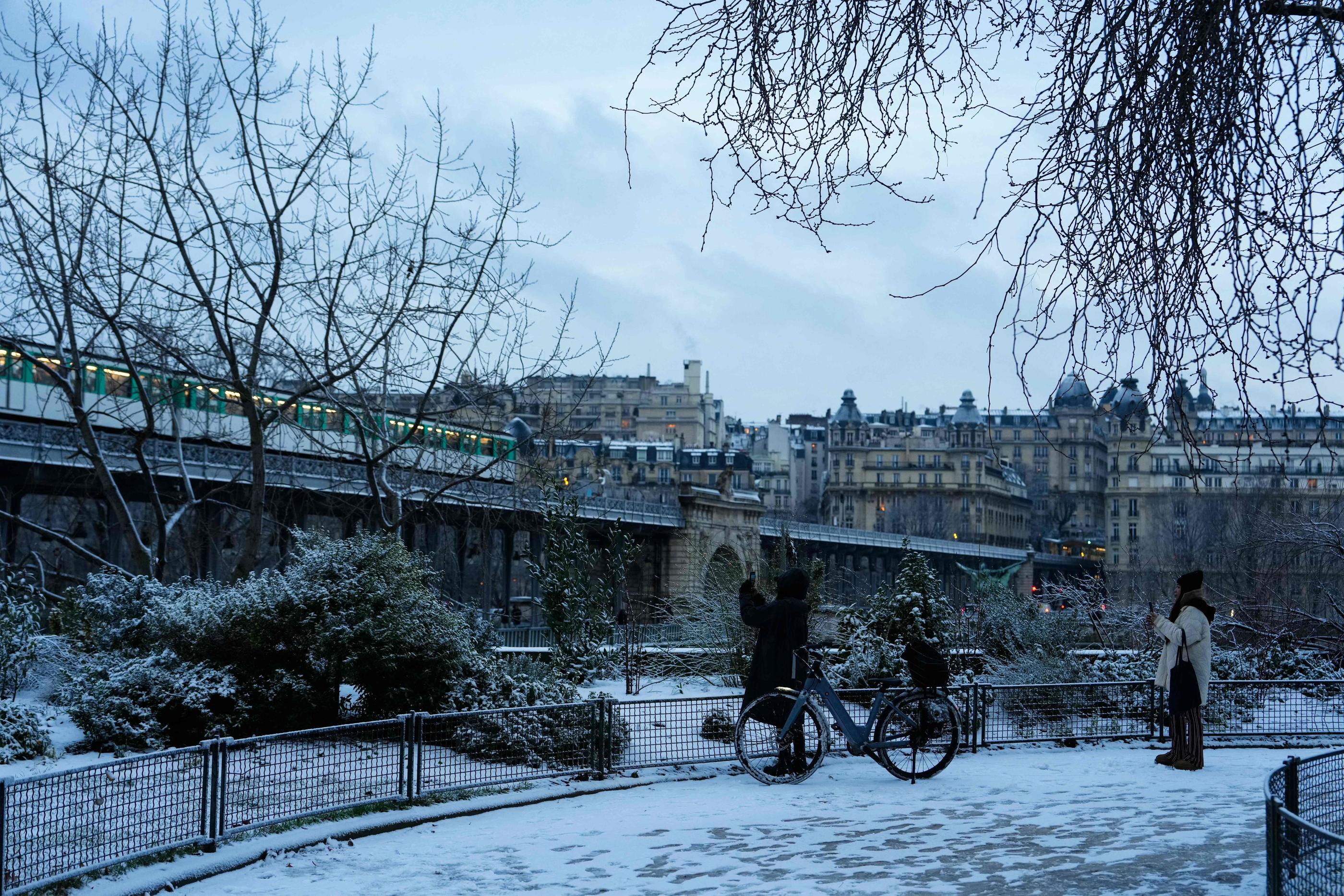 A Paris, ce jeudi, une fine couche de neige couvre les trottoirs, comme ici du côté du pont de Bir-Hakeim. AFP/Dimitar Dilkoff
