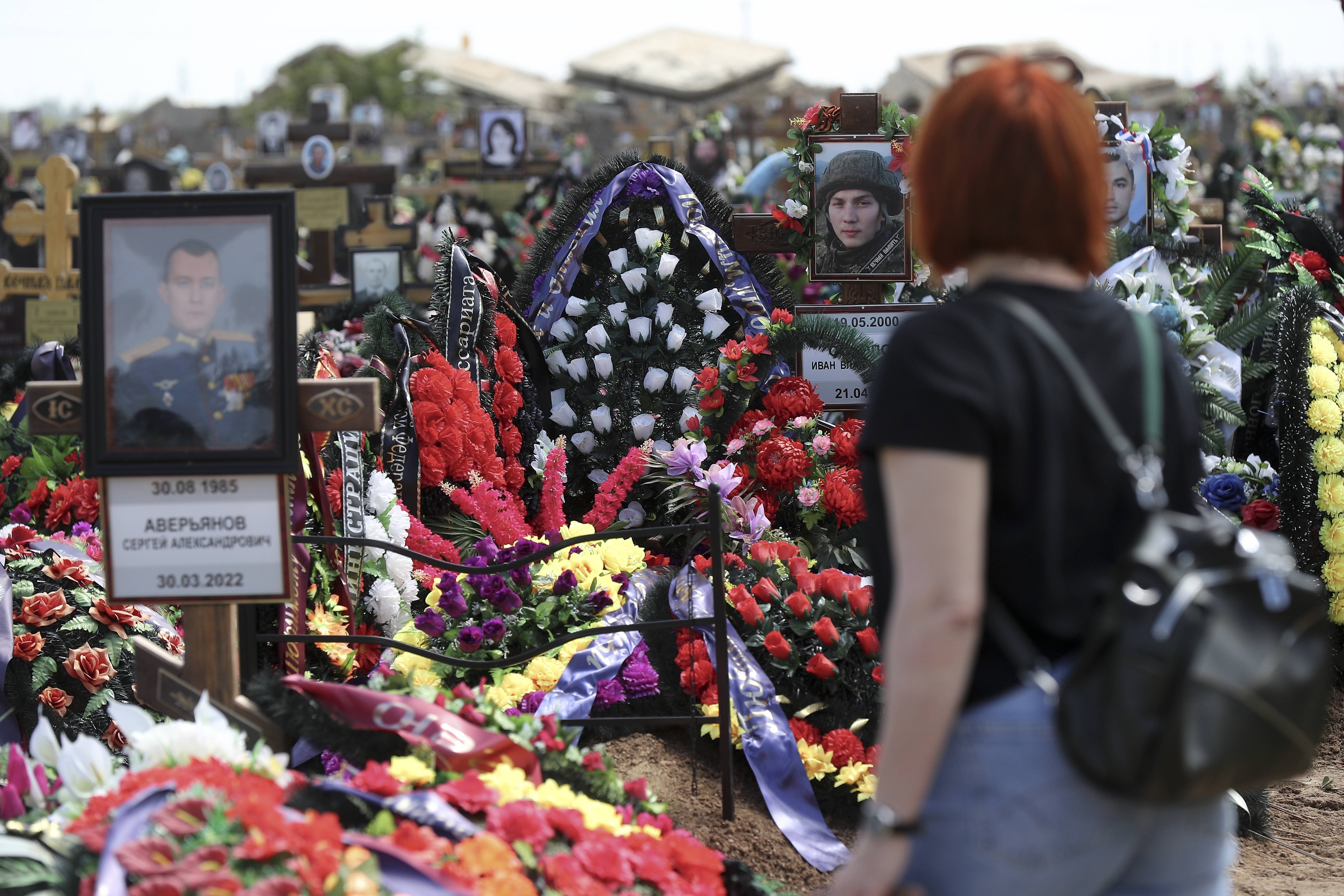 Près de Volgograd (Russie), une femme se recueille sur les tombes de soldats russes morts au front. Si le chiffre global de tués est caché par l'État, les Si les chiffres globaux de tués au front sont cachés par l'État russe, les soldats morts au combat sont néanmoins portés en héros.  AP Photo