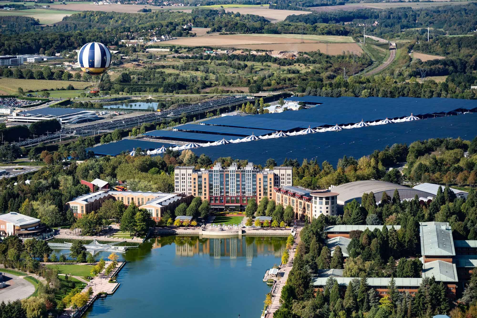 Avec 82 000 panneaux photovoltaïques installés sur son parking visiteurs, Disneyland Paris dispose désormais de la plus grande centrale solaire à ombrières d'Europe (au centre). DR.