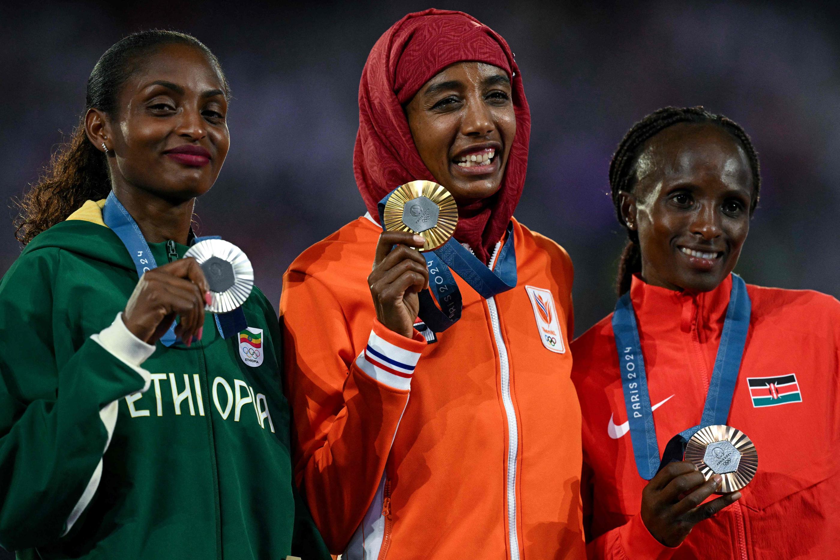 Sifan Hassan (Pays-Bas) au centre, entourée de Tigist Assefa (Éthiopie) et Hellen Obiri (Kenya), ont été acclamées ce dimanche soir par plus de 80 000 spectateurs. AFP/OLI SCARFF