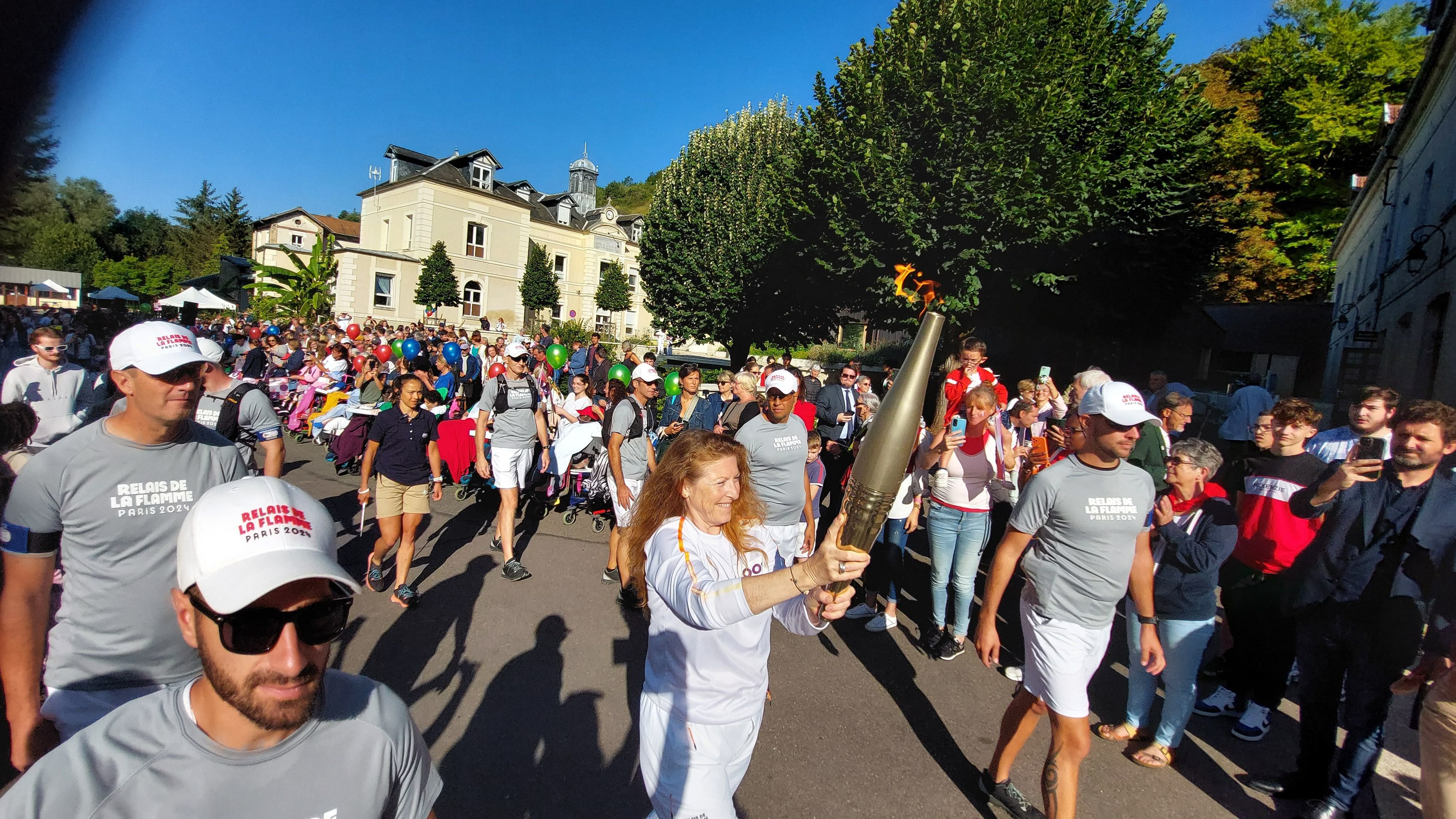 La Roche-Guyon (Val-d'Oise), mardi 27 août. La flamme, dans les mains de Françoise Baysset, l'une des relayeuses, est partie du parc de l'hôpital de la Roche-Guyon, dédié depuis près de deux siècles aux enfants polyhandicapés. LP/Aurélie Foulon