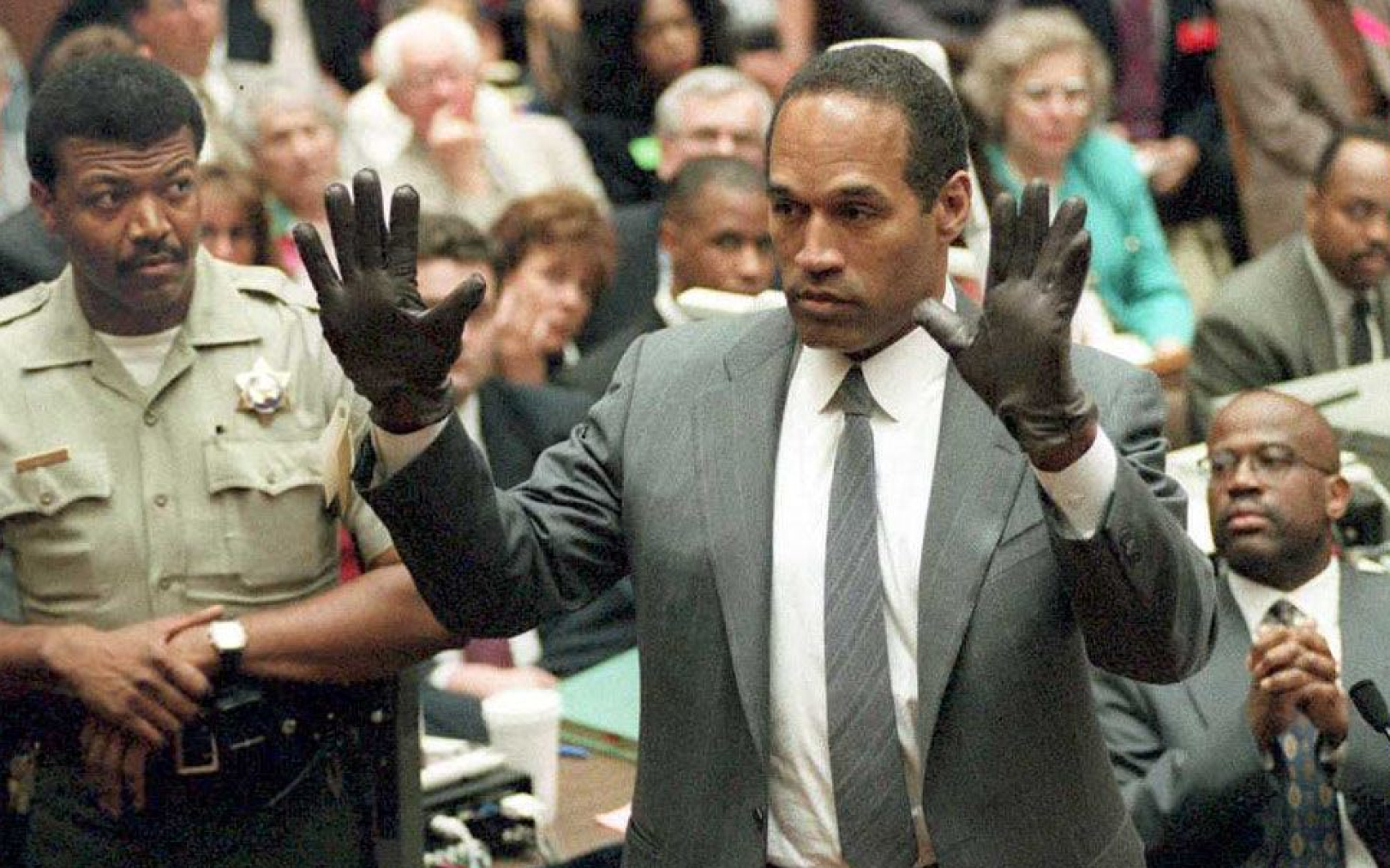 Le 21 juin 1995, lors de son procès à Los Angeles, O.J. Simpson essaye des gants ensanglantés retrouvés au 875 Bundy Drive, là où son ex-femme Nicole Brown a été retrouvée morte poignardée, un an plus tôt.  AFP/Vince Bucci