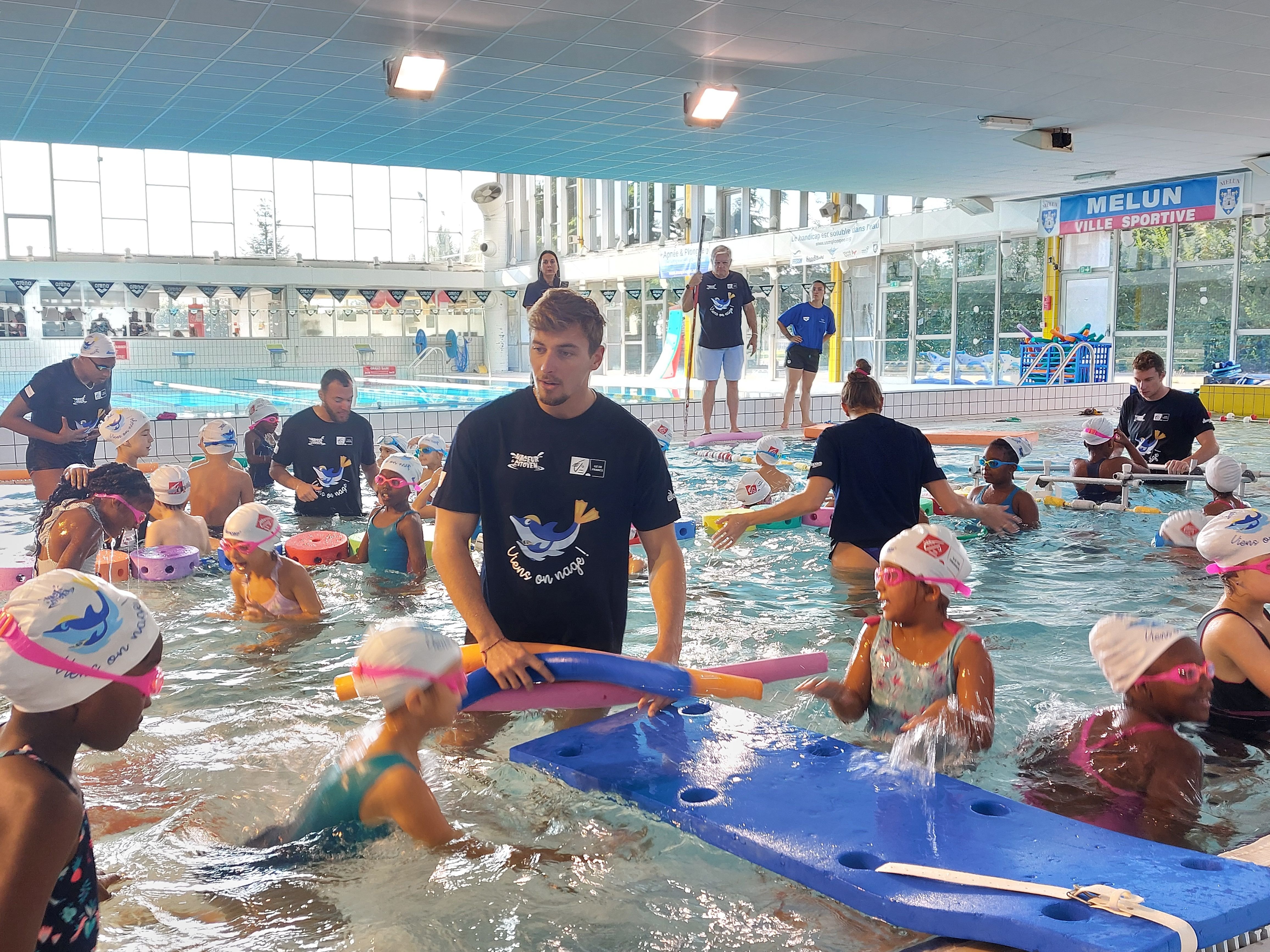 Melun, ce mercredi. Maxime Grousset (au 1er plan), médaillé de bronze aux JO de Paris 2024 au relais 4 X 100 m quatre nages par équipe, met en confiance les enfants dans l'eau. LP/Sophie Bordier