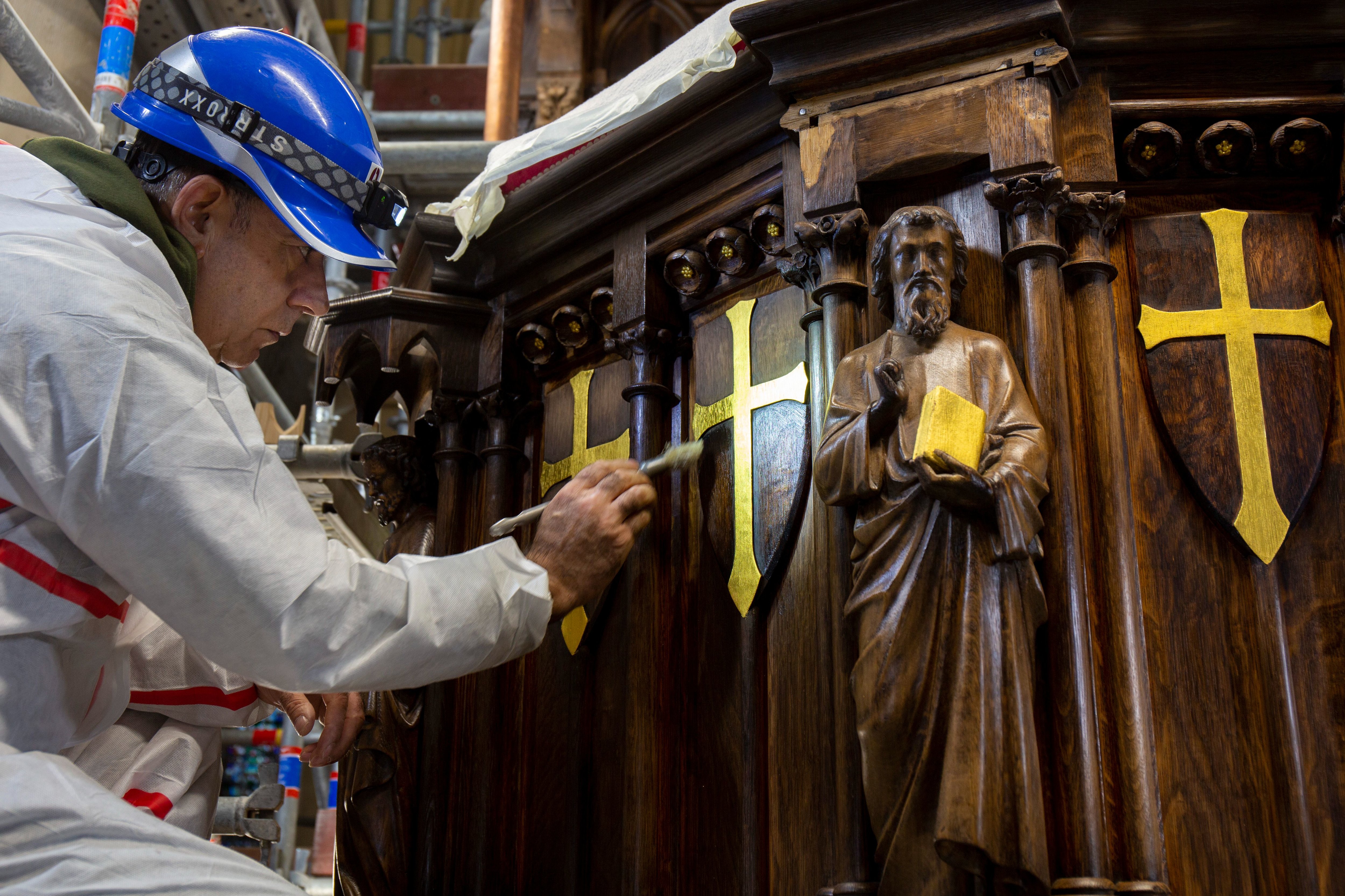 Ici, un artisan applique de la cire avant le lustrage du bois de la chaire à prêcher de la cathédrale Notre-Dame. Rebâtir Notre-Dame de Paris/David Bordes