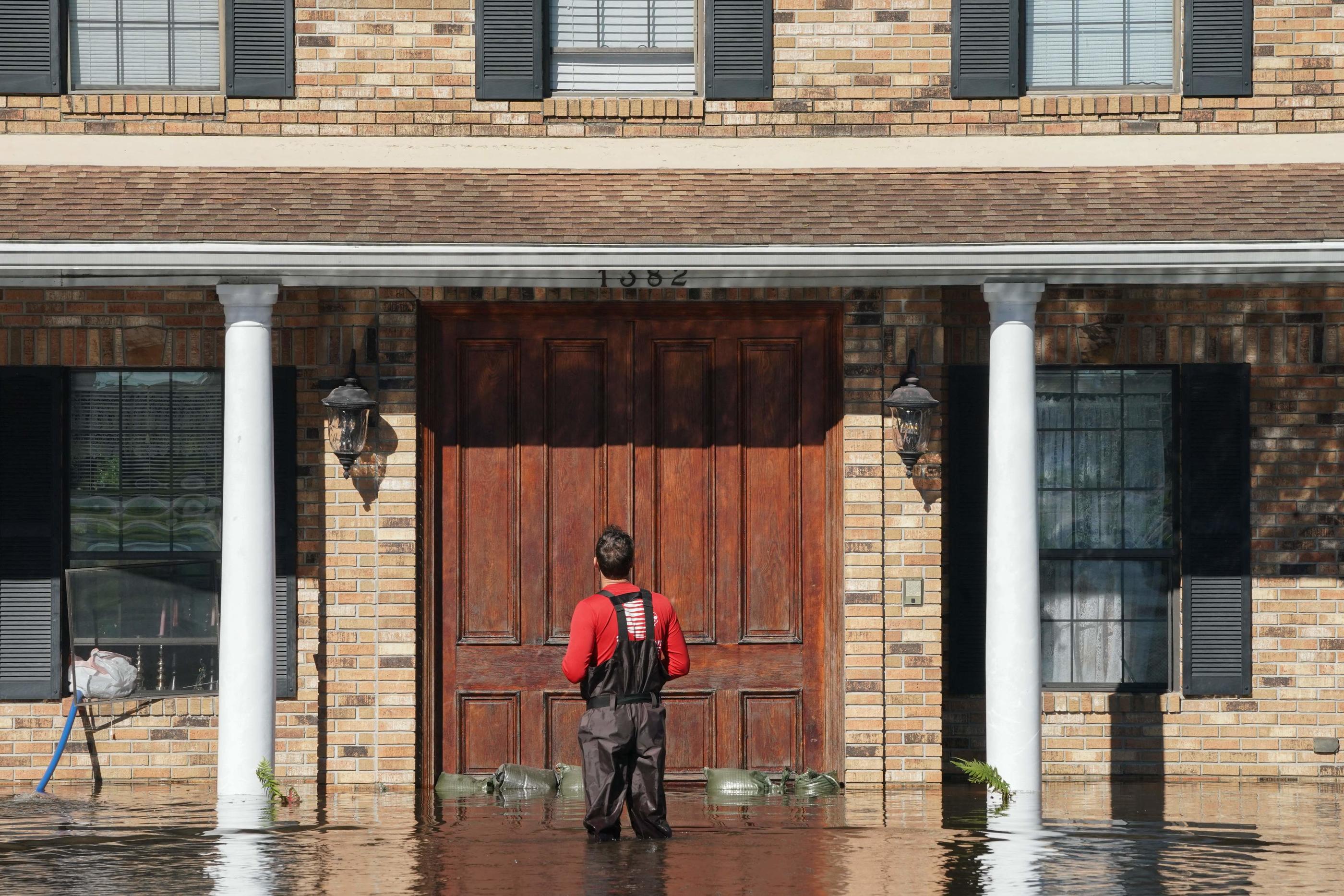 Un homme s'arrête devant sa maison alors qu'un ruisseau déborde à cause des inondations provoquées par l'ouragan Ian, le 30 septembre 2022 à Kissimmee, en Floride. AFP/Bryan R. Smith