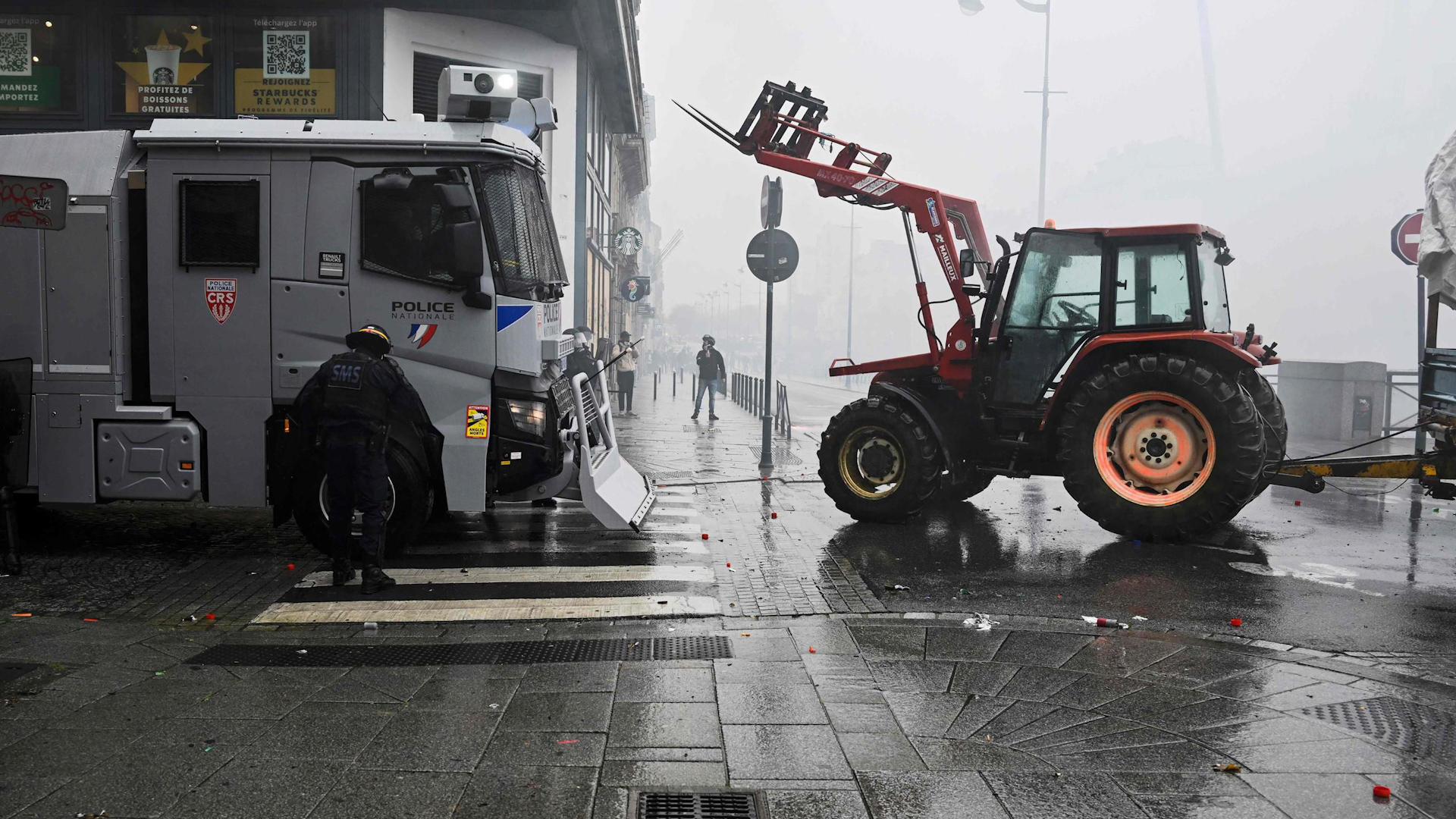 Rennes (Ille-et-Vilaine), le 22 mars 2023. Face aux canons à eau, les manifestants se sont protégés derrière... un tracteur qui avançait sans chauffeur
