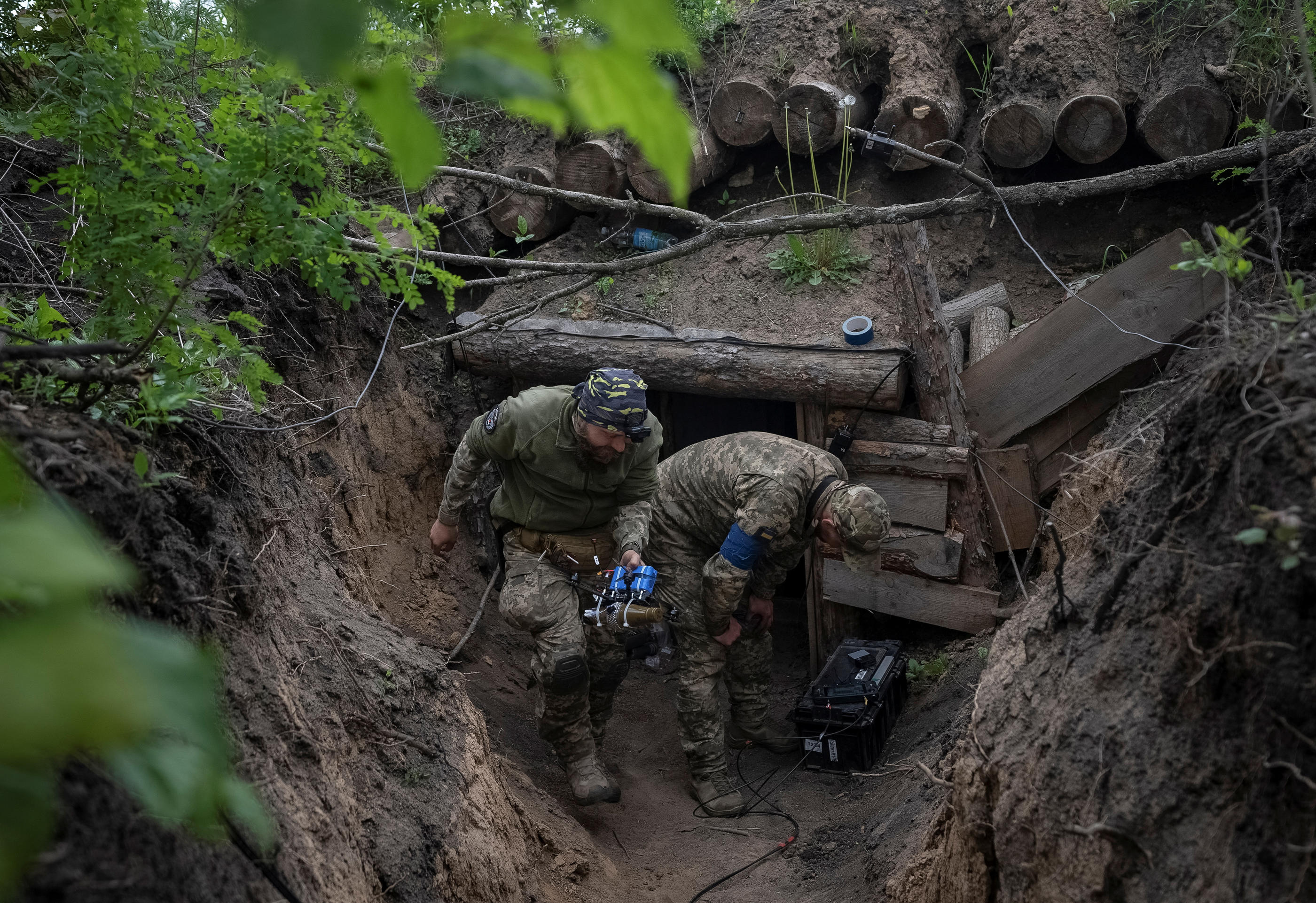 Des soldats ukrainiens dans une tranchée s'apprêtent à envoyer un drone d'attaque, dans la région de Kharkiv (Ukraine), le 15 mai 2024. Reuters/Inna Varenytsia