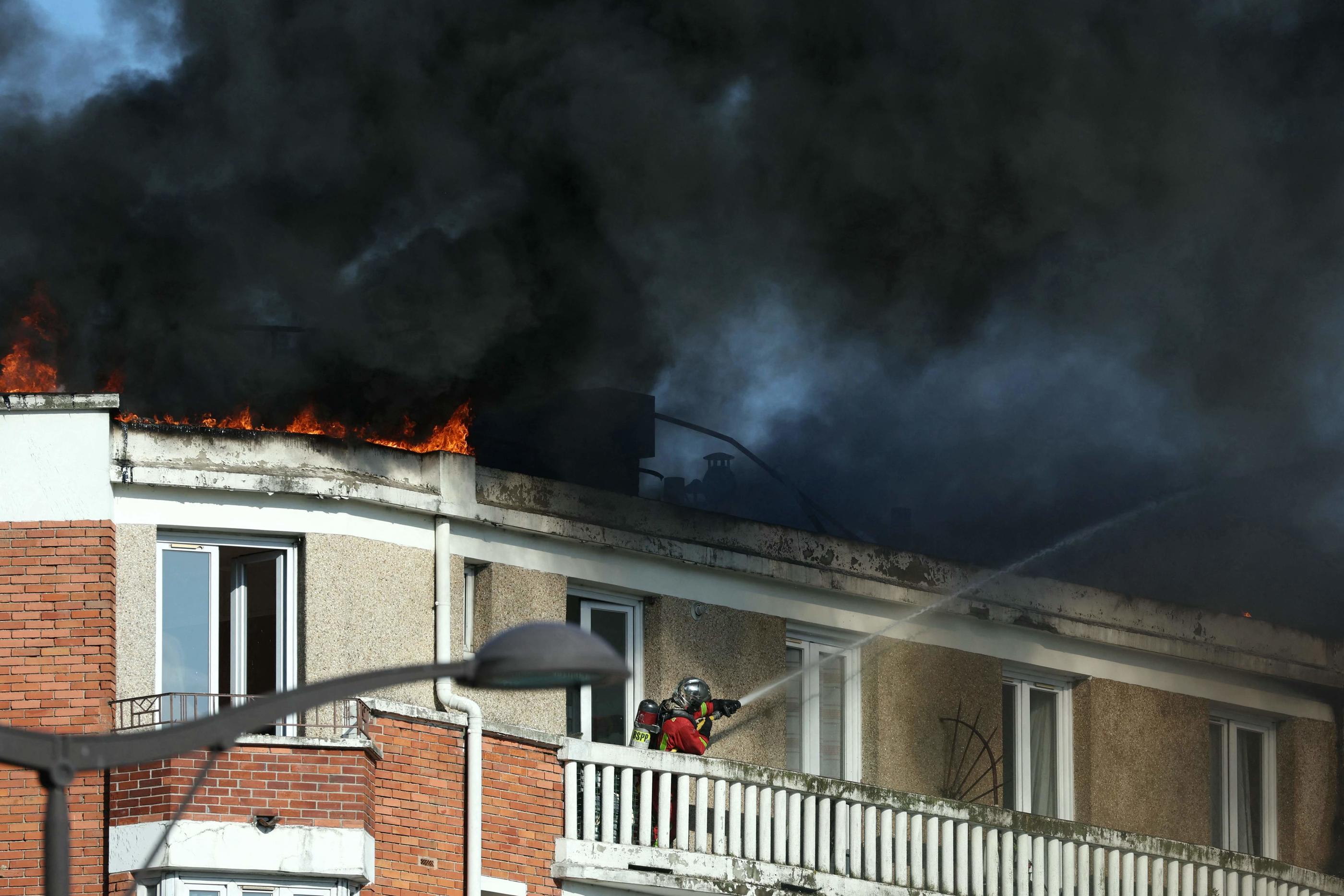 Paris (XIIIe), ce mardi 17 septembre. L’incendie a pris sur le toit-terrasse de l’immeuble, qui était en travaux, selon la police. Deux bouteilles de gaz ont explosé en raison des flammes. AFP/Thomas Samson