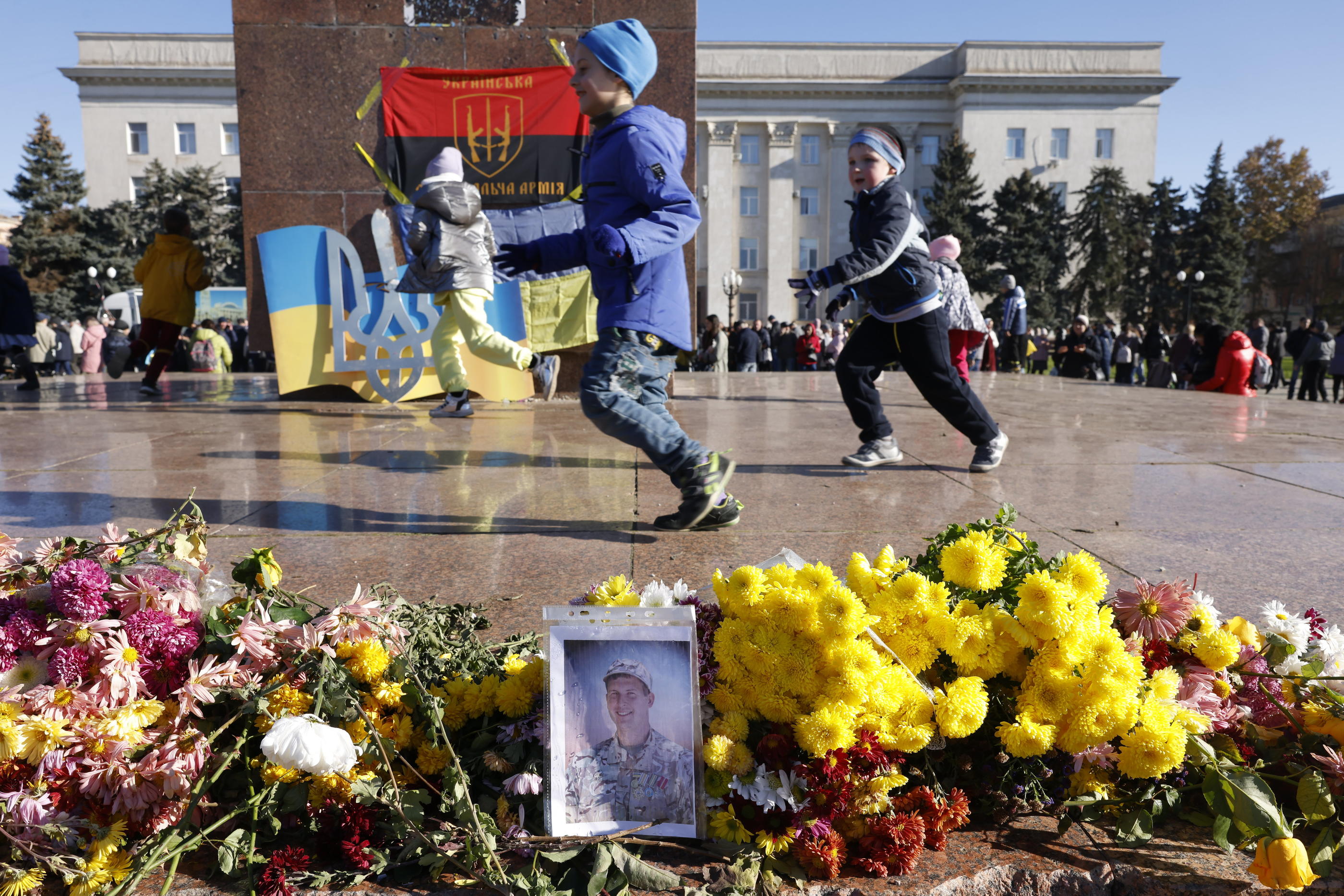 Dans les rues de Kherson libérées par les Ukrainiens après le retrait russe, des enfants jouent devant des photos qui rendent hommage à des soldats morts au combat. LP/Olivier Corsan