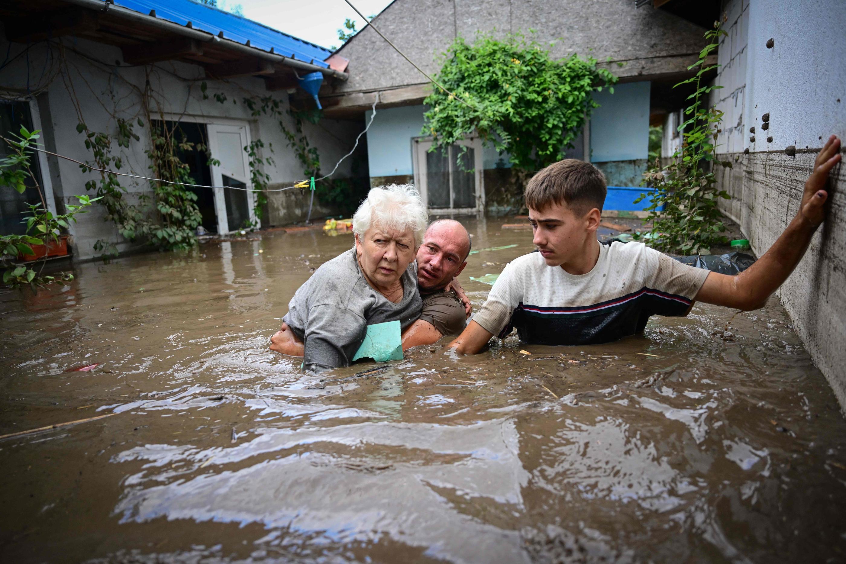 Des habitants viennent en aide à une personne âgée dans le village de Slobozia Conachi (Roumanie), le 14 septembre 2024. AFP/Daniel Mihailescu