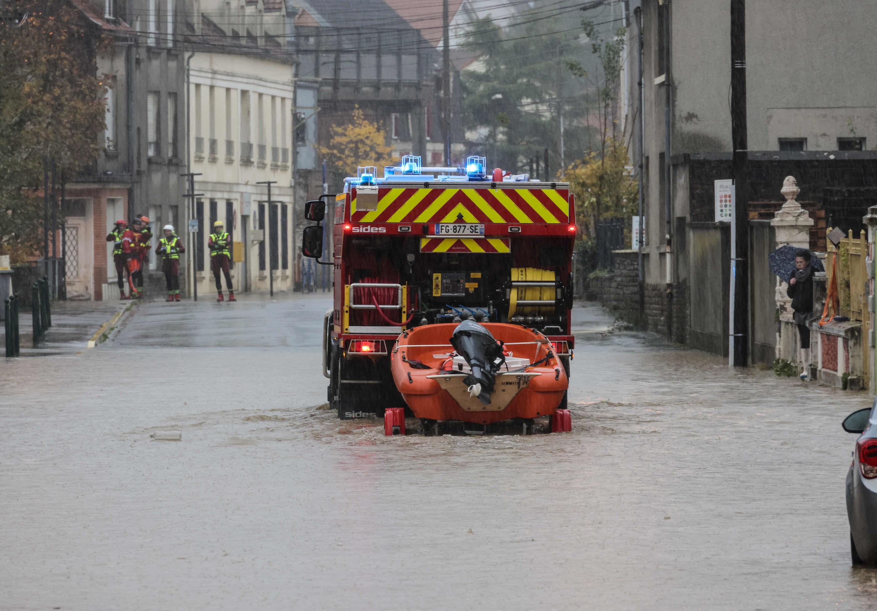 Un camion de pompiers remorquant un canot pneumatique dans une rue inondée du village d'Isques, près de Boulogne-sur-Mer (Pas-de-Calais). AFP/Denis Charlet