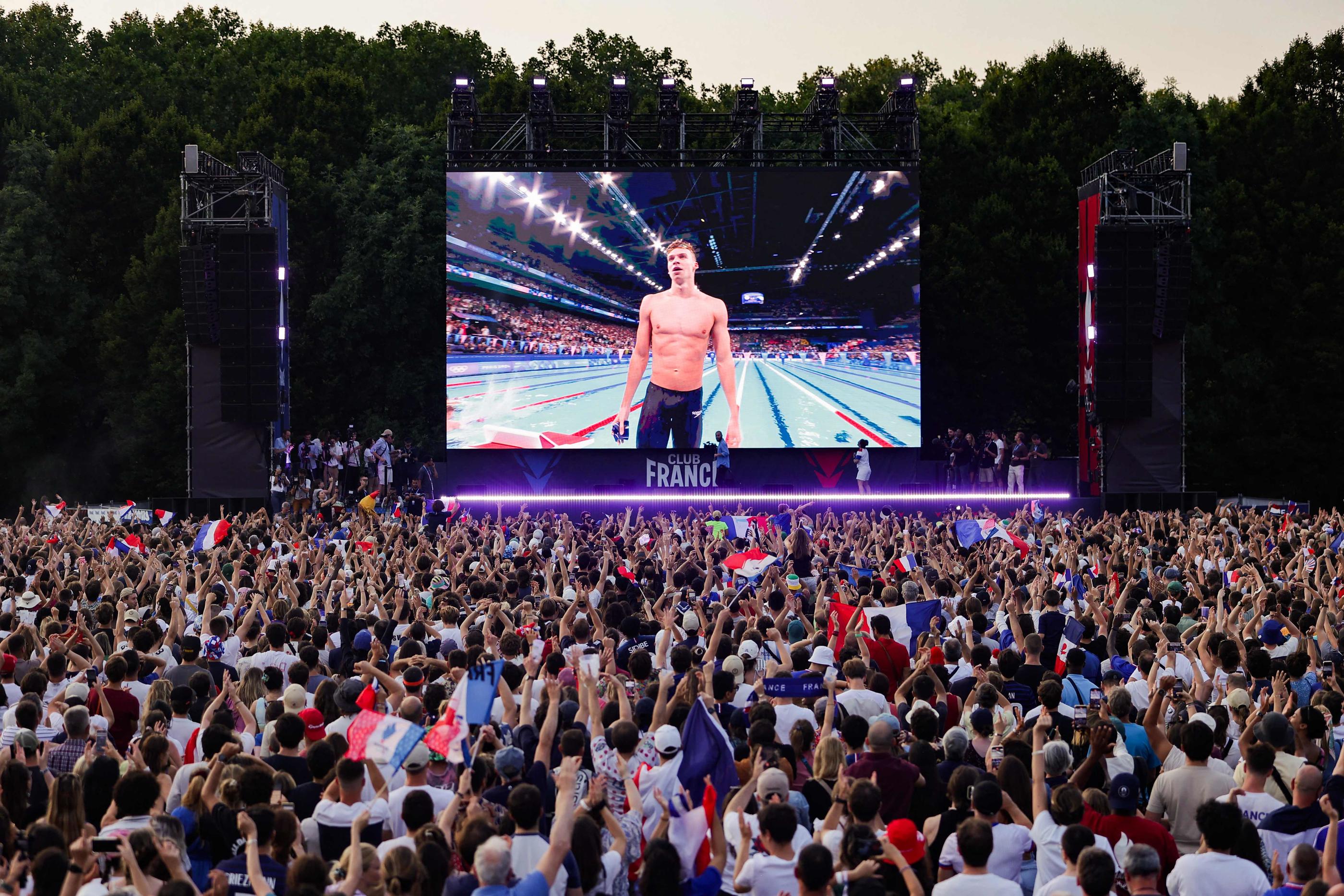 Les fans-zones ont vibré ce vendredi (ici le Club France au parc des Nations, à Paris XIXe, après la victoire de Léon Marchand au 200 m 4 nages) au rythme des médailles récoltées par les Français. AFP/Thibaud Moritz