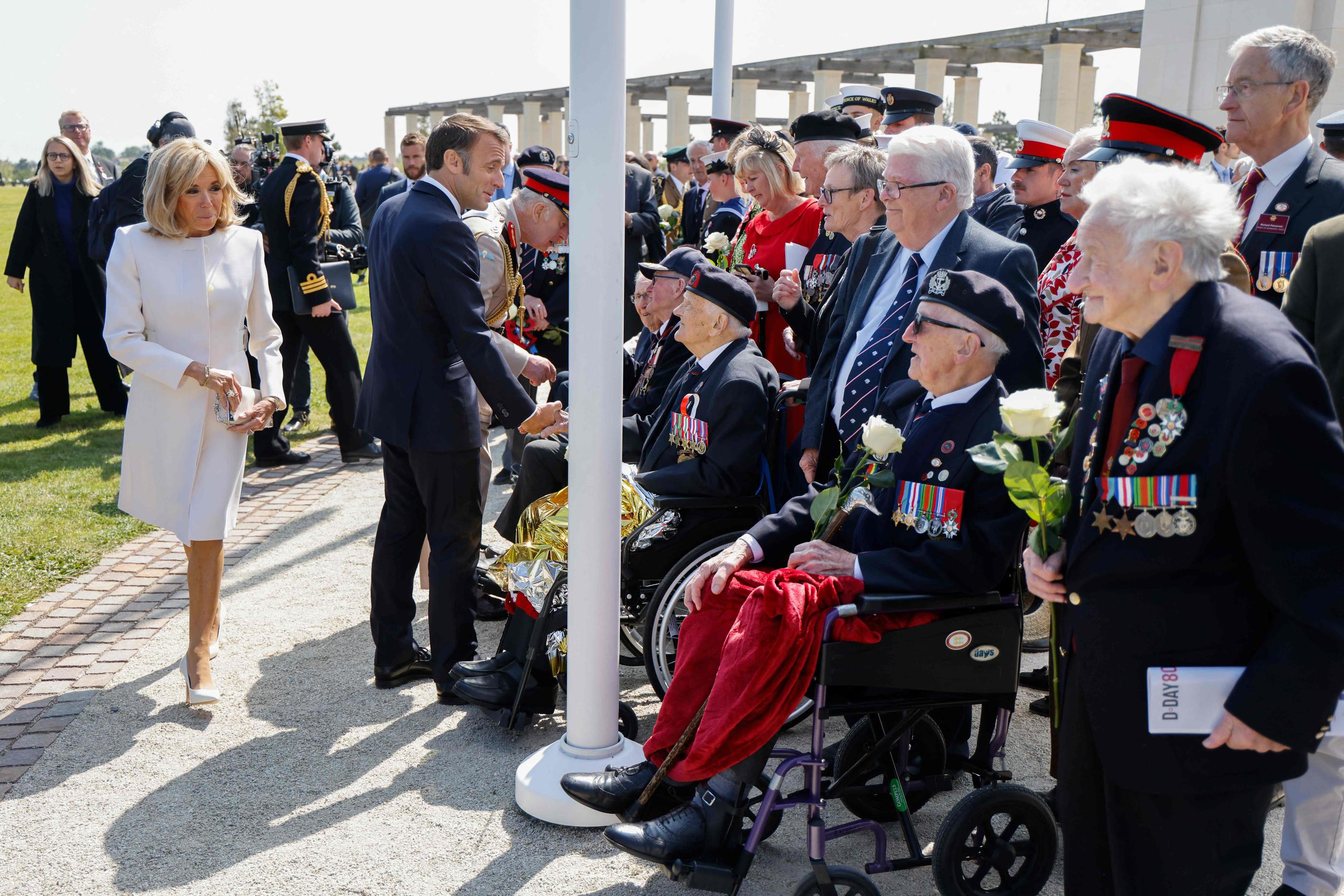 Brigitte et Emmanuel Macron saluant des vétérans britanniques à Ver-sur-Mer (Calvados) le 6 juin 2024 lors des cérémonies du Débarquement. AFP/Ludovic MARIN
