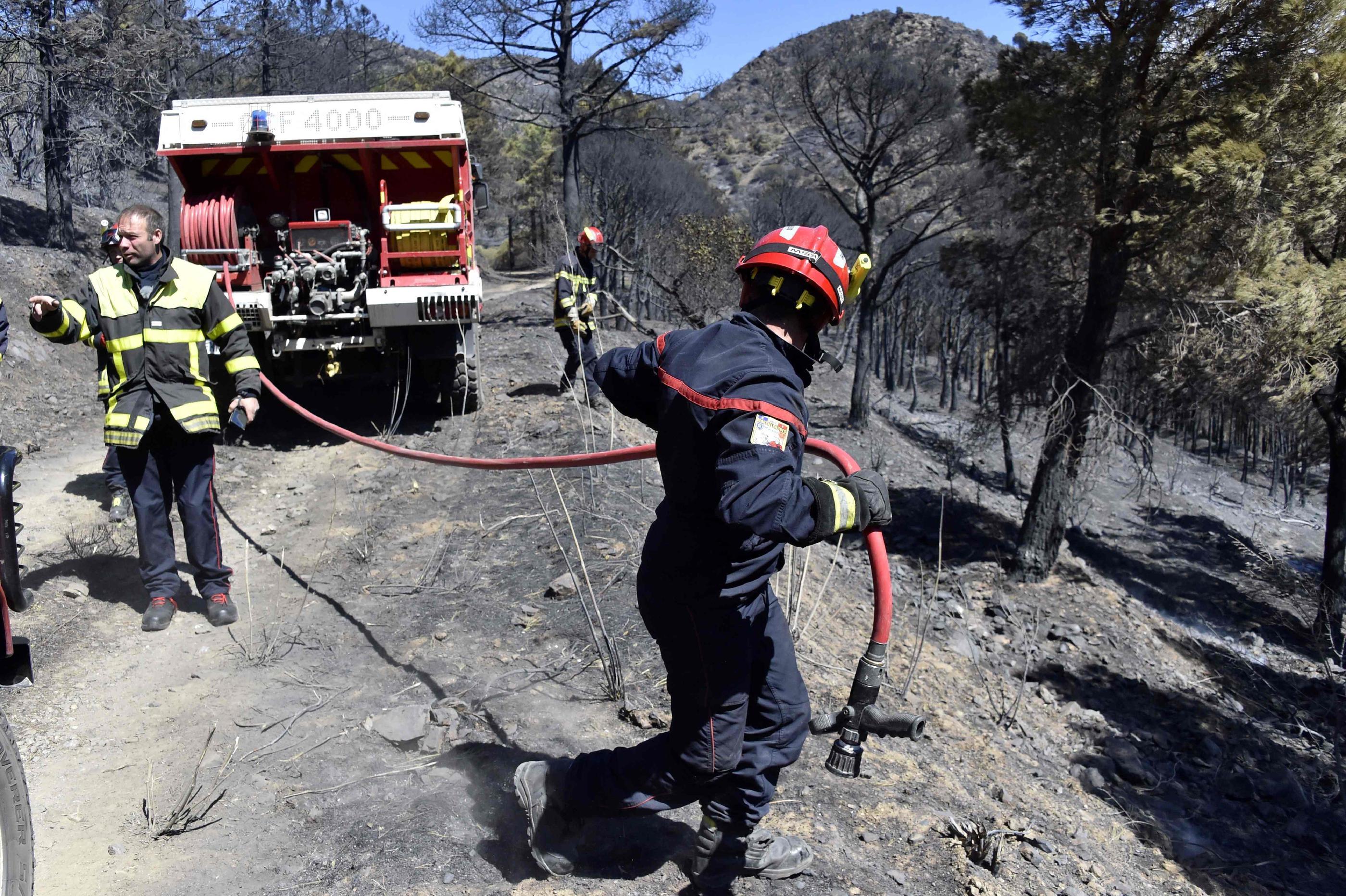Des pompiers éteignant un incendie près de Cerbère, dans les Pyrénées-Orientales, le 17 avril 2023. AFP/RAYMOND ROIG