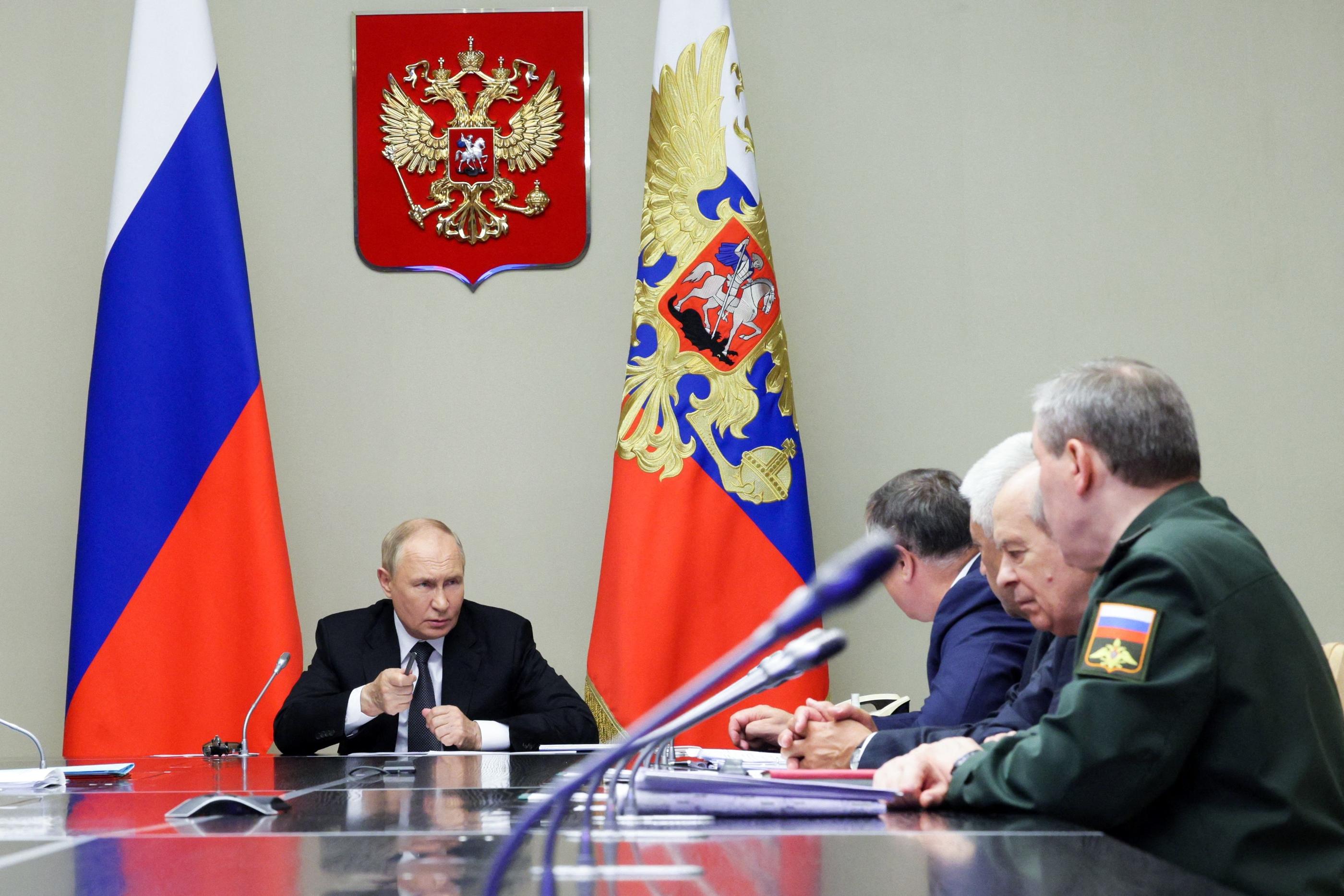 Le président russe Vladimir Poutine aux côtés de responsables des forces de sécurité, le 12 août 2024, lors d'une réunion sur la situation dans la région de Koursk, attaquée par l'armée ukrainienne. AFP/Gavriil Grigorov