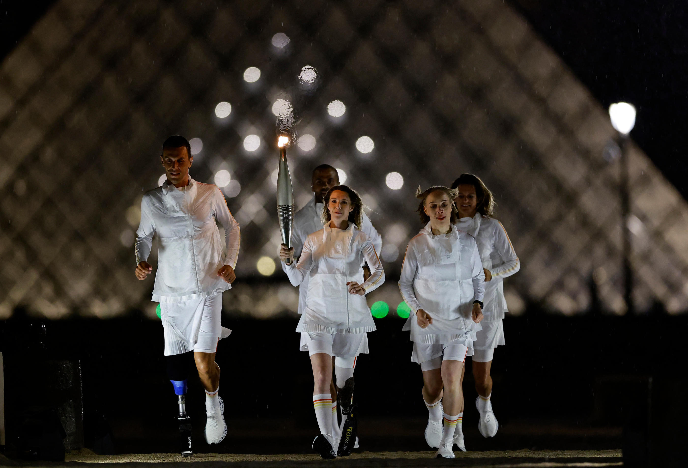 Marie-Amélie Le Fur, entourée d'Alexis Hanquinquant, Nantenin Keïta (Tony Parker et Amélie Mauresmo en arrière-plan). Reuters/Uselei Marcelino