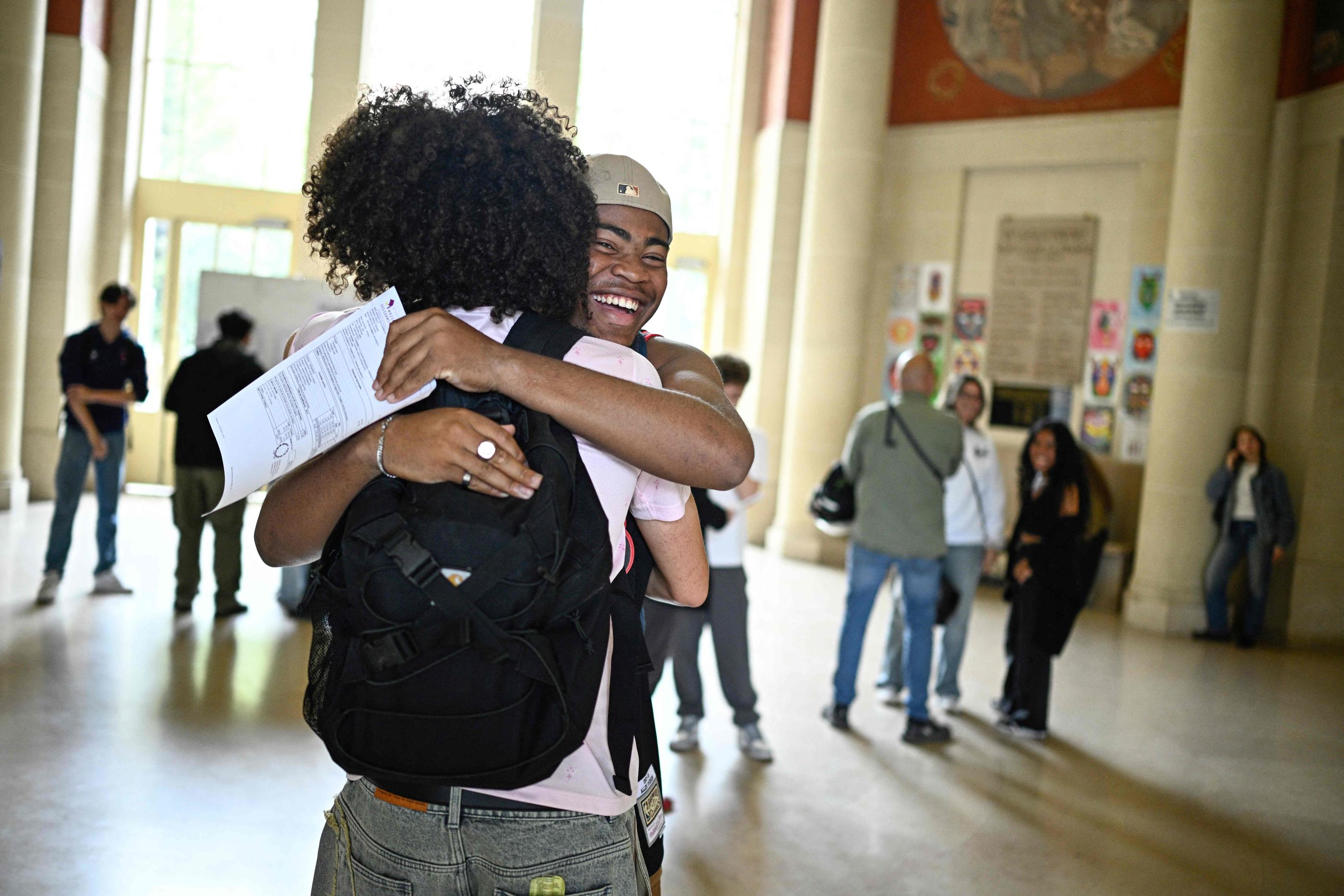 Des élèves sautent de joie en découvrant leurs résultats du bac au lycée Claude Bernard à Paris. AFP