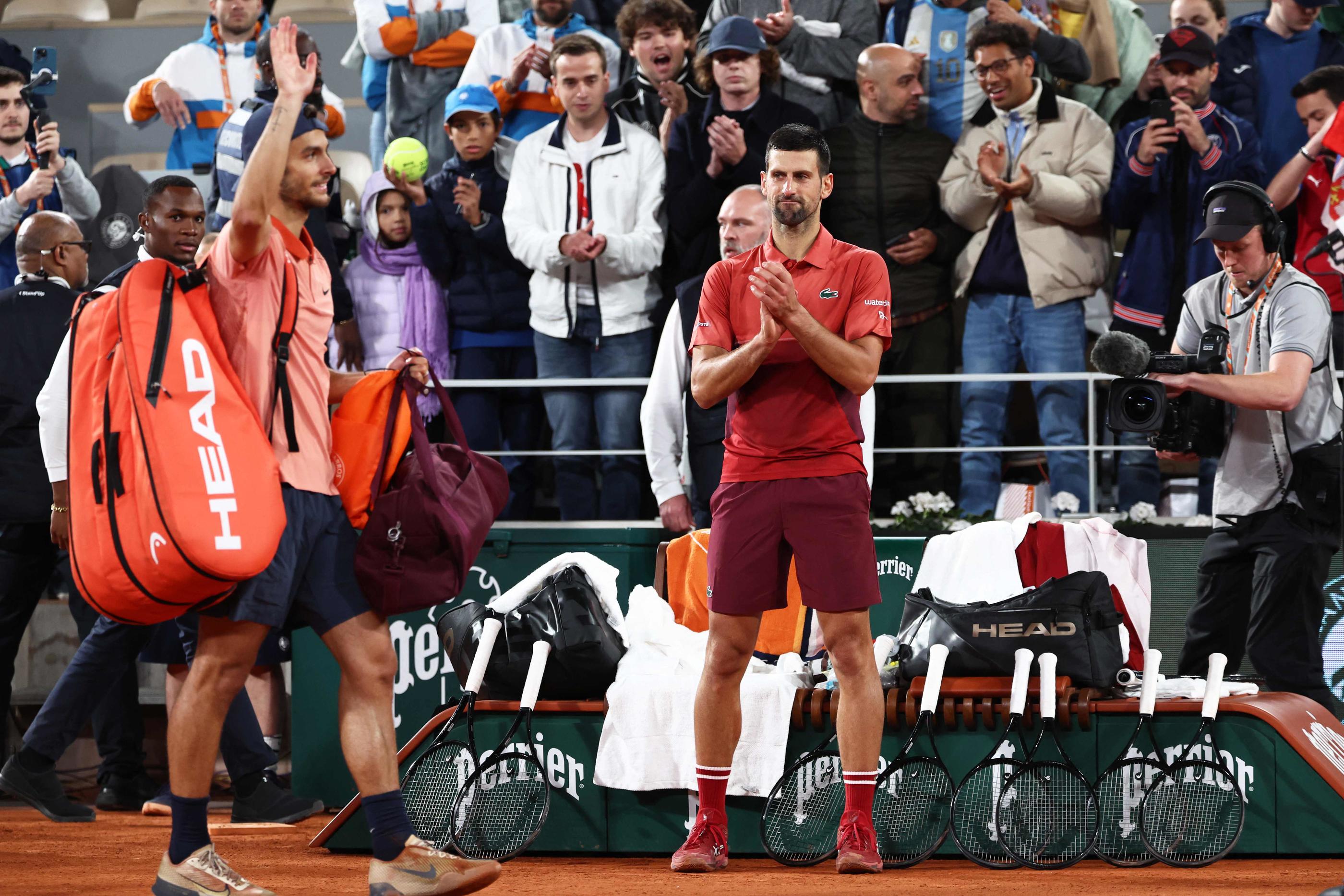 Novak Djokovic salue Lorenzo Musetti à sa sortie du court. Les deux hommes se sont livré un combat monstrueux dans la nuit parisienne. (Photo EMMANUEL DUNAND / AFP)