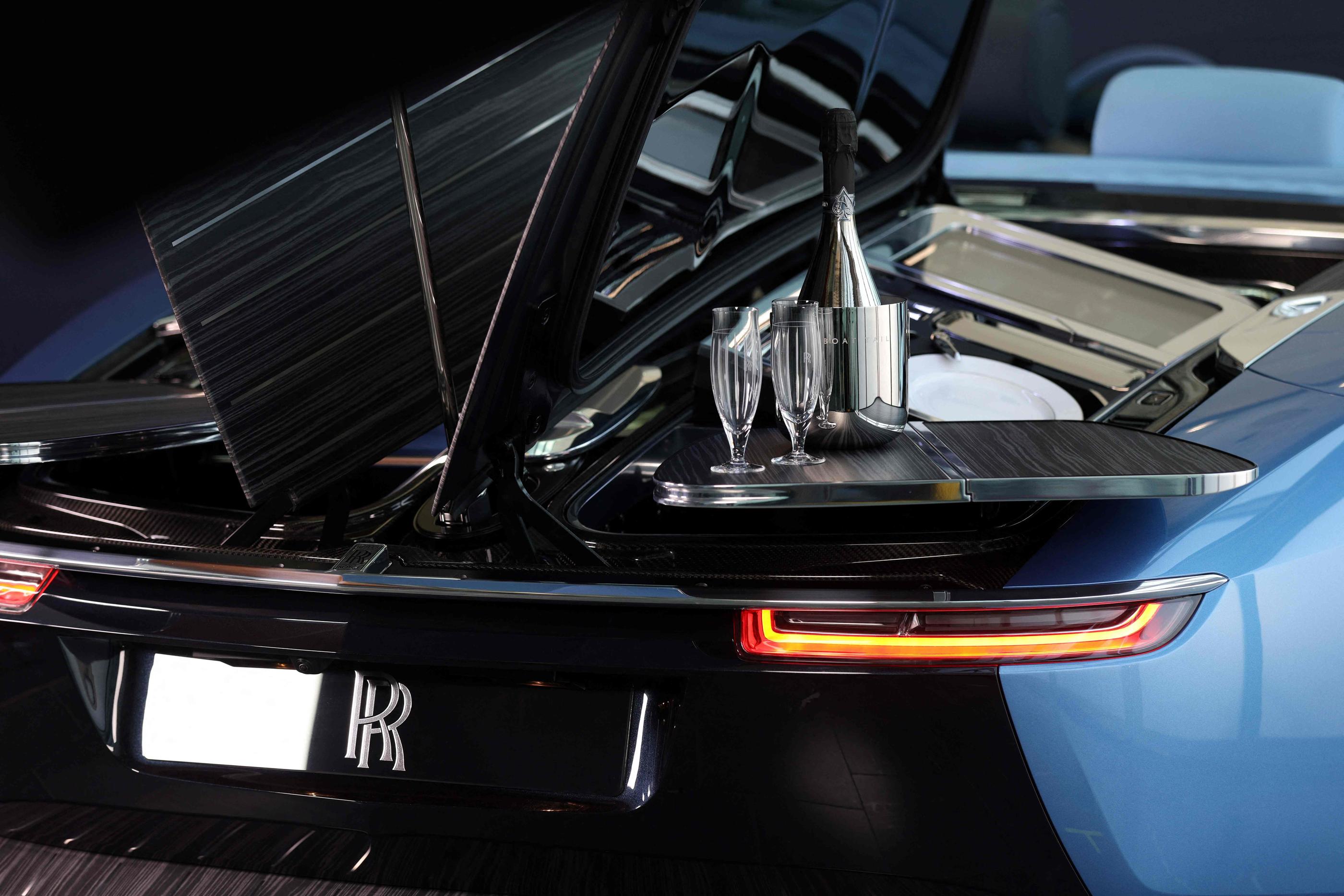 Sur ce modèle conçu par Rolls-Royce, les pans de l'arrière de la nouvelle voiture se lèvent latéralement pour former comme une table abritée par un parasol.