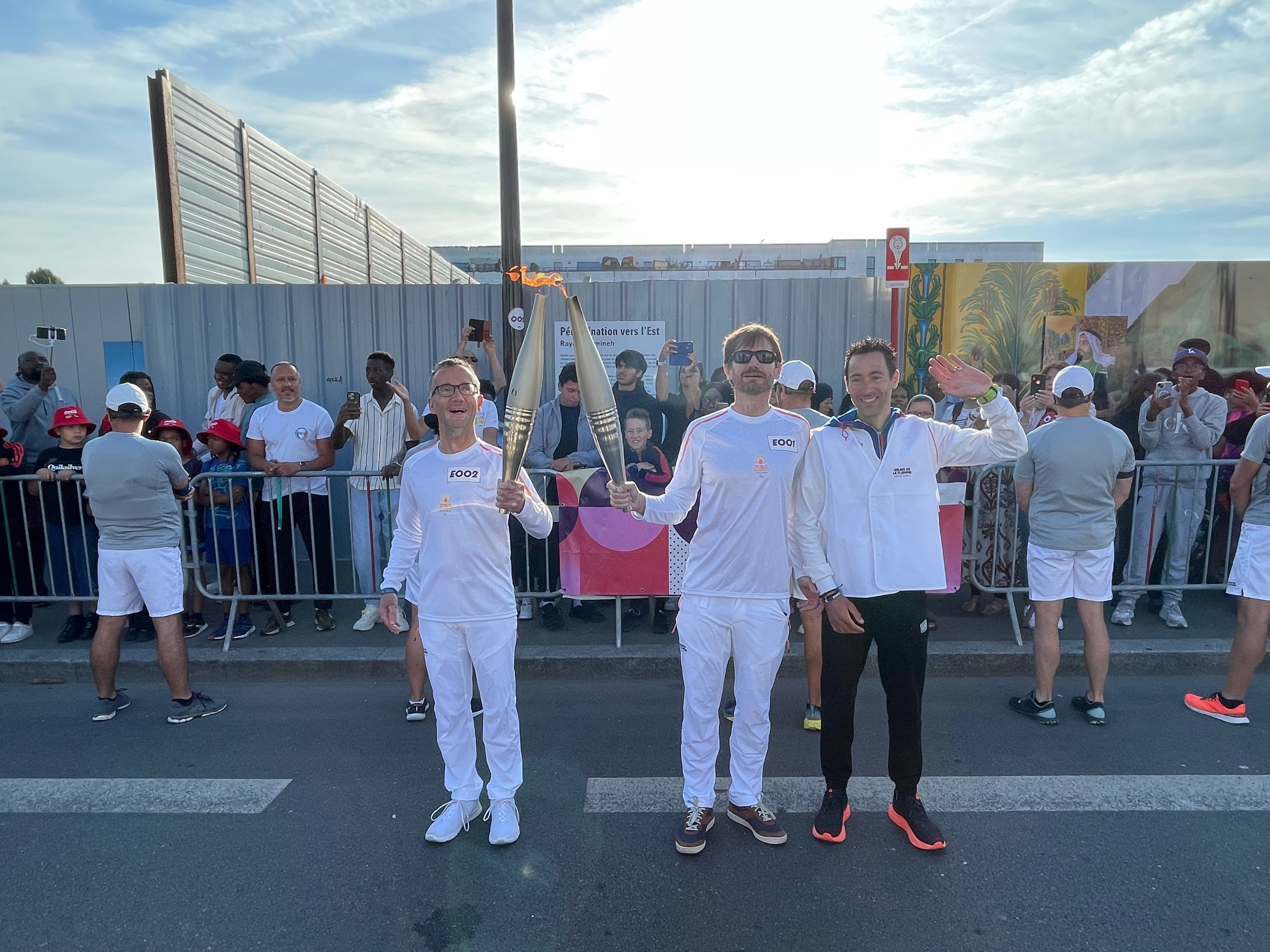 Montfermeil, ce mardi matin. L'ancien paracycliste Olivier Donval (au centre) et son guide ont été les premiers porteurs de la flamme paralympique en Seine-Saint-Denis. Ils ont passé le relais à Claude Revert, un marathonien normand. LP/N.G.