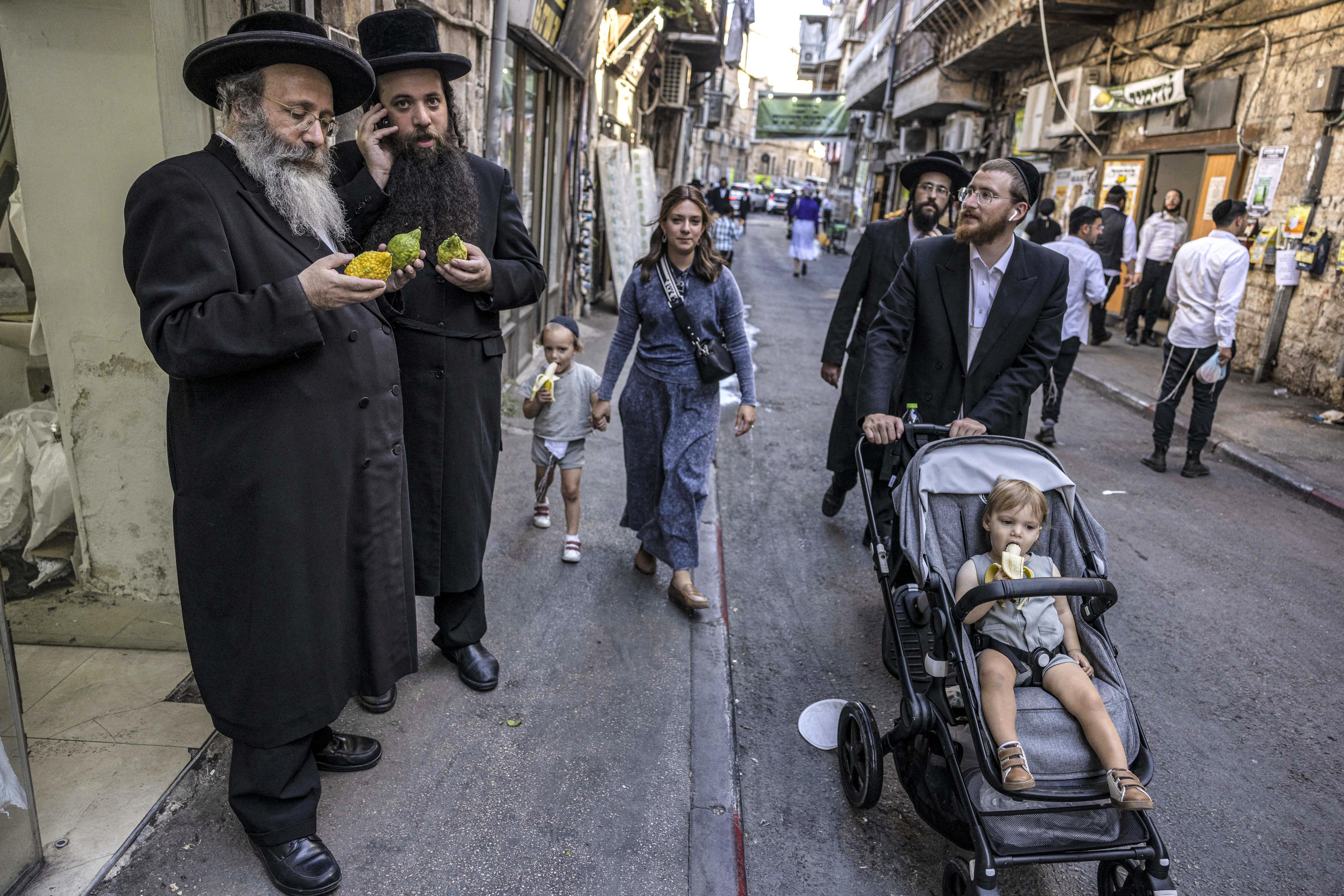 Des juifs ultraorthodoxes inspectent les etrogim (citrons), éléments importants du rituel de la fête de Souccot, dans le quartier de Mea Shearim à Jérusalem, le 27 septembre 2023. AFP/Kahana Menahem