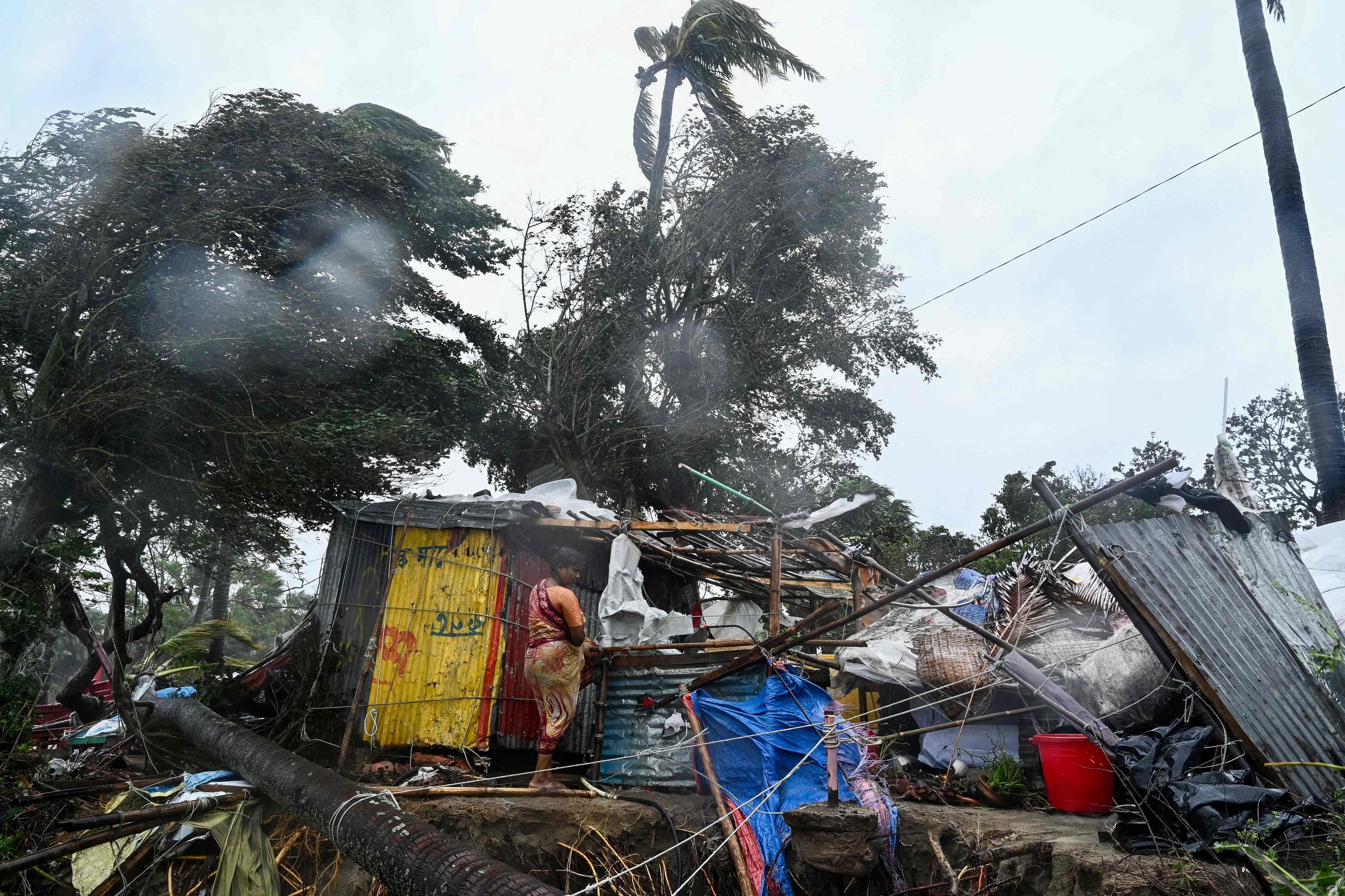 Une femme à côté de sa maison détruite après le passage du cyclone Remal sur la plage de Kuakata le 27 mai 2024. AFP/MUNIR UZ ZAMAN
