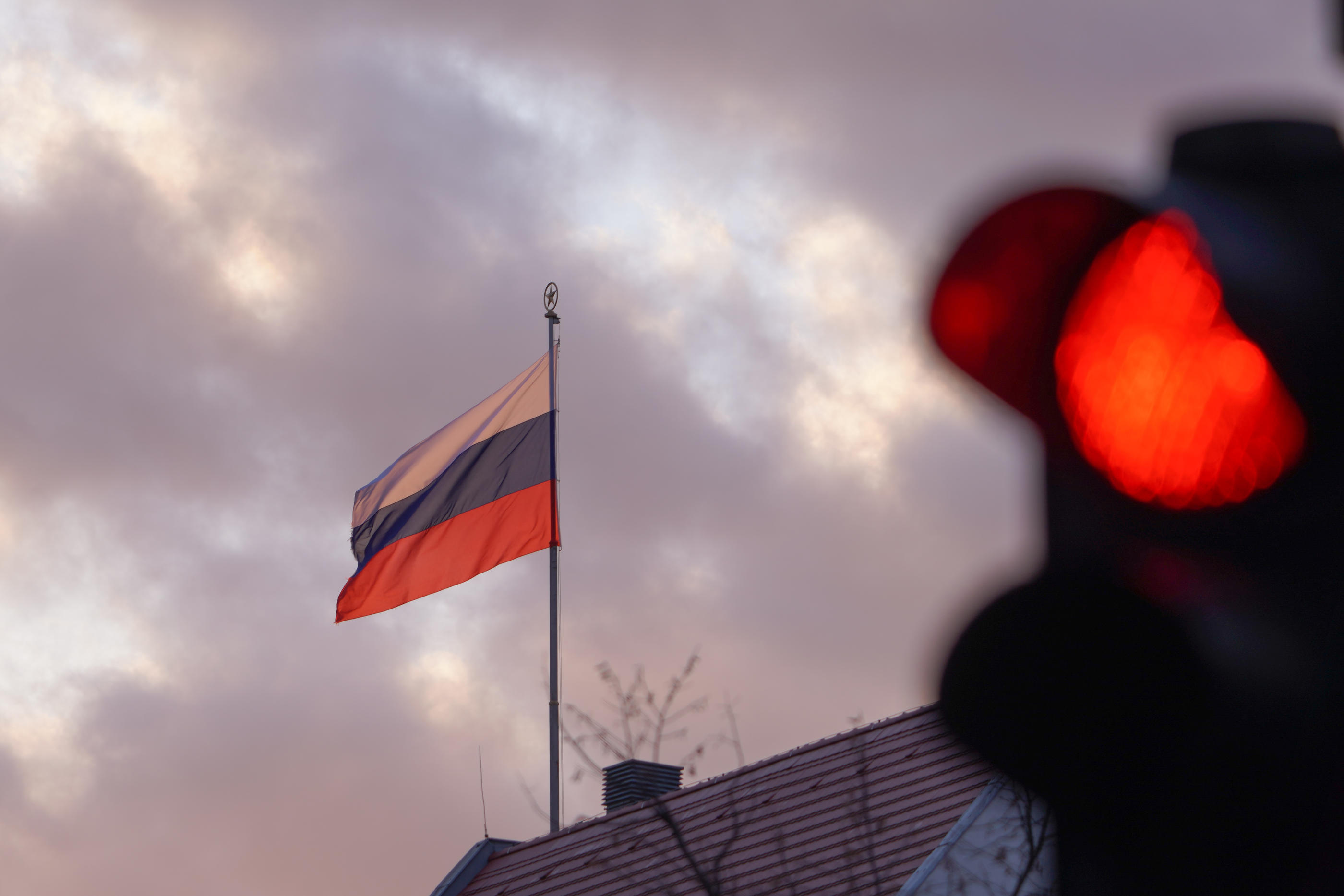 FILED - 24 February 2022, Berlin: The flag of the Russian Embassy flies behind a red traffic light in the early morning. Photo: Joerg Carstensen/dpa - Photo by Icon sport