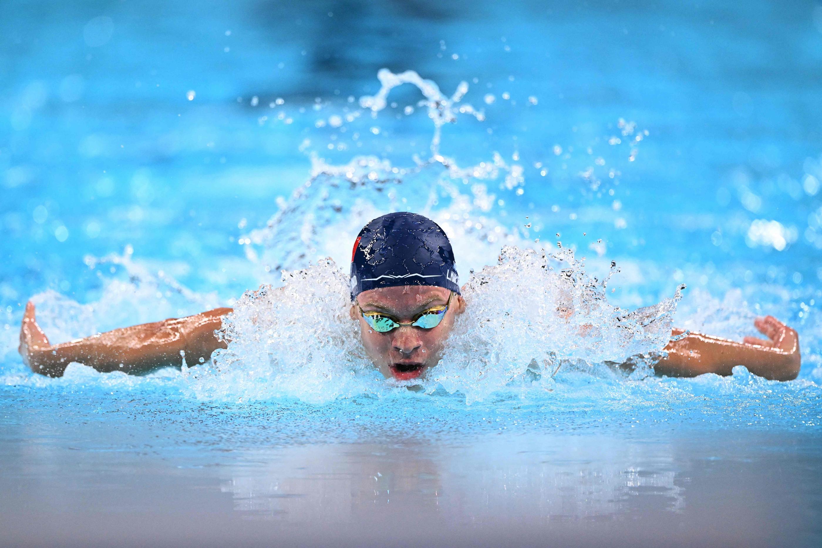 TOPSHOT - France's Leon Marchand competes in a semifinal of the men's 200m butterfly swimming event during the Paris 2024 Olympic Games at the Paris La Defense Arena in Nanterre, west of Paris, on July 30, 2024. (Photo by SEBASTIEN BOZON / AFP)