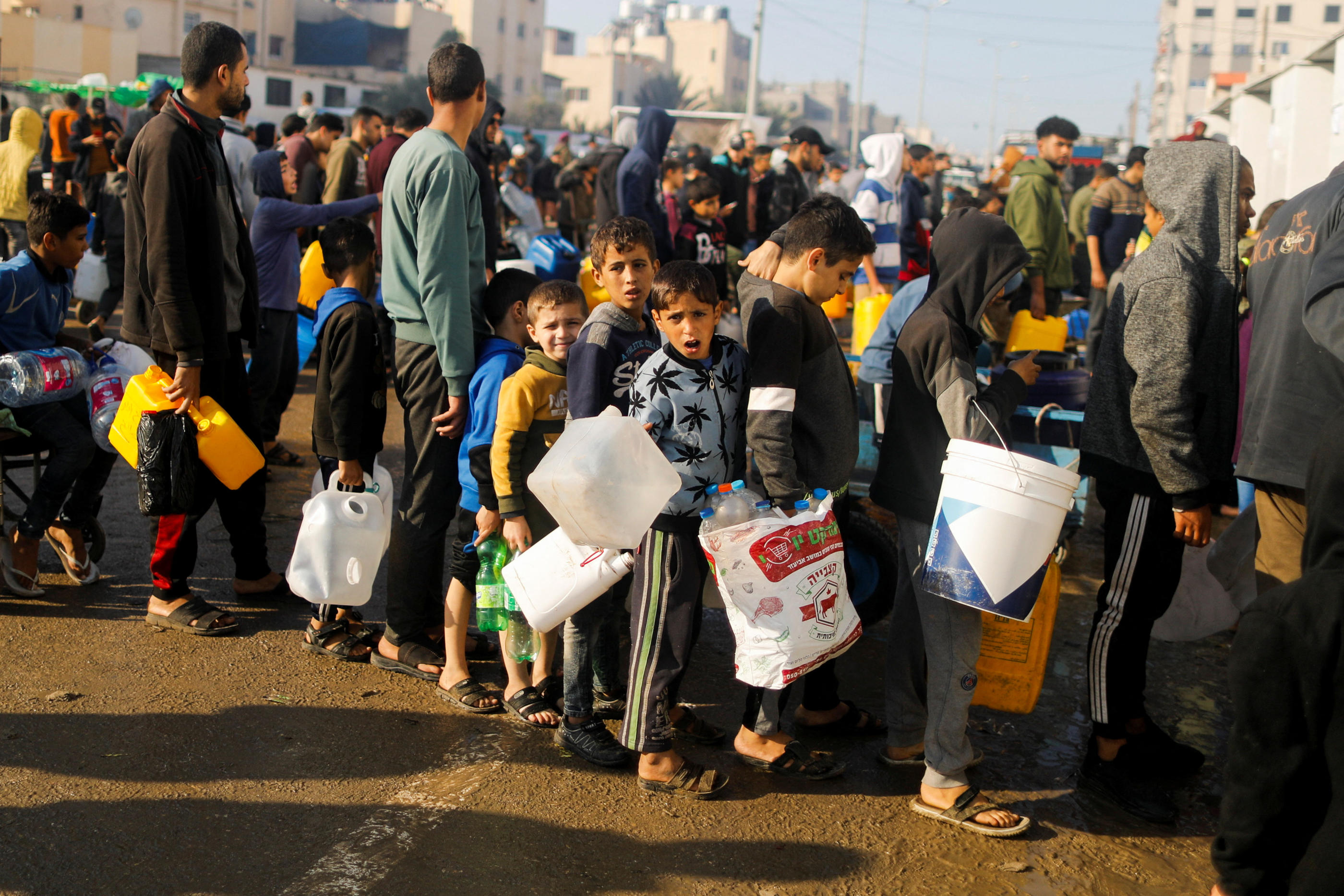 Des enfants palestiniens font la queue pour aller chercher de l'eau potable à Rafah. REUTERS/Saleh Salem