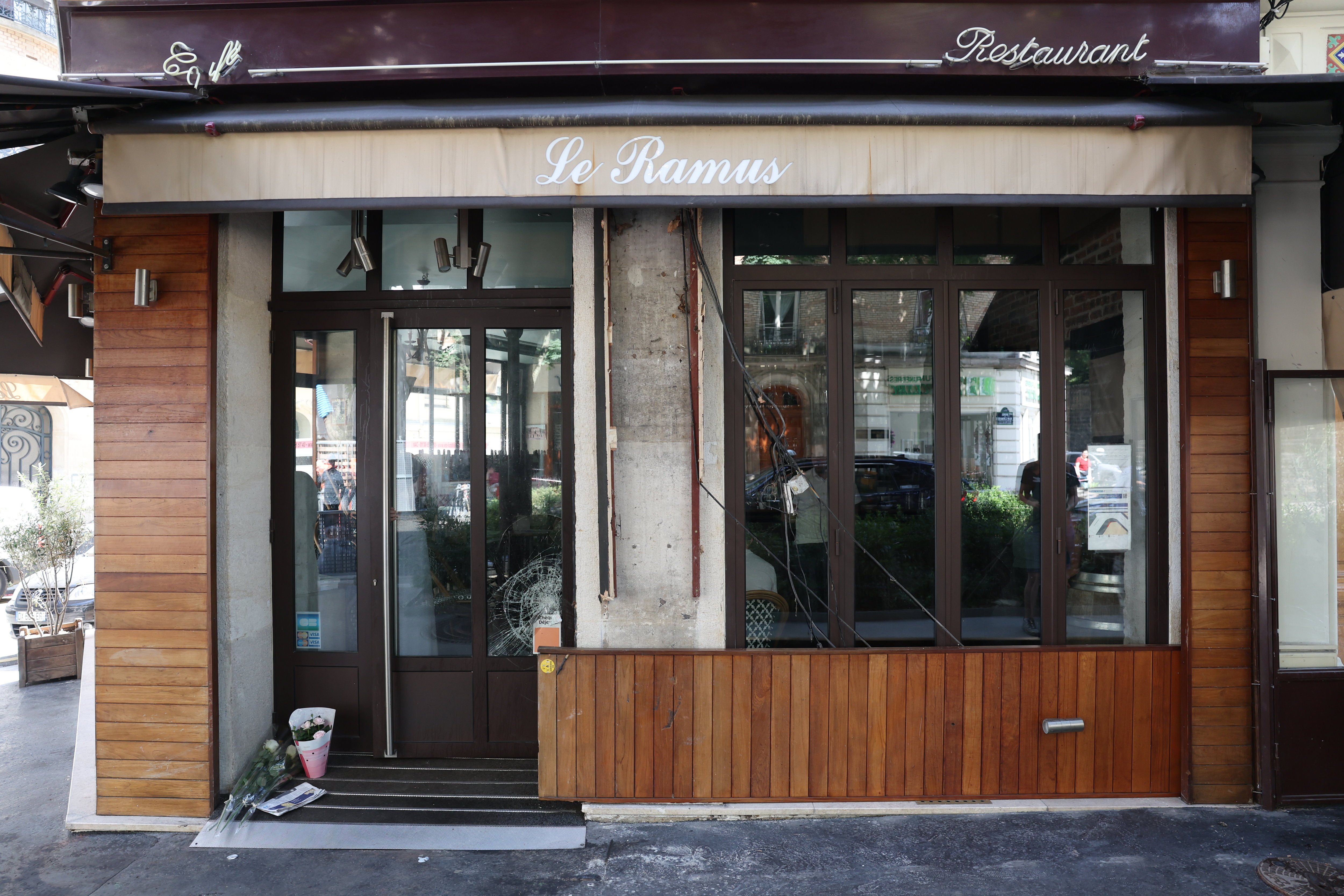 Des roses blanches et une bougie ont été déposées par des passants, ce jeudi matin, à l'endroit même où une voiture a fini sa course, mercredi soir, fauchant plusieurs clients installés à la terrasse du Ramus, à Paris (XXe). LP/Arnaud Journois